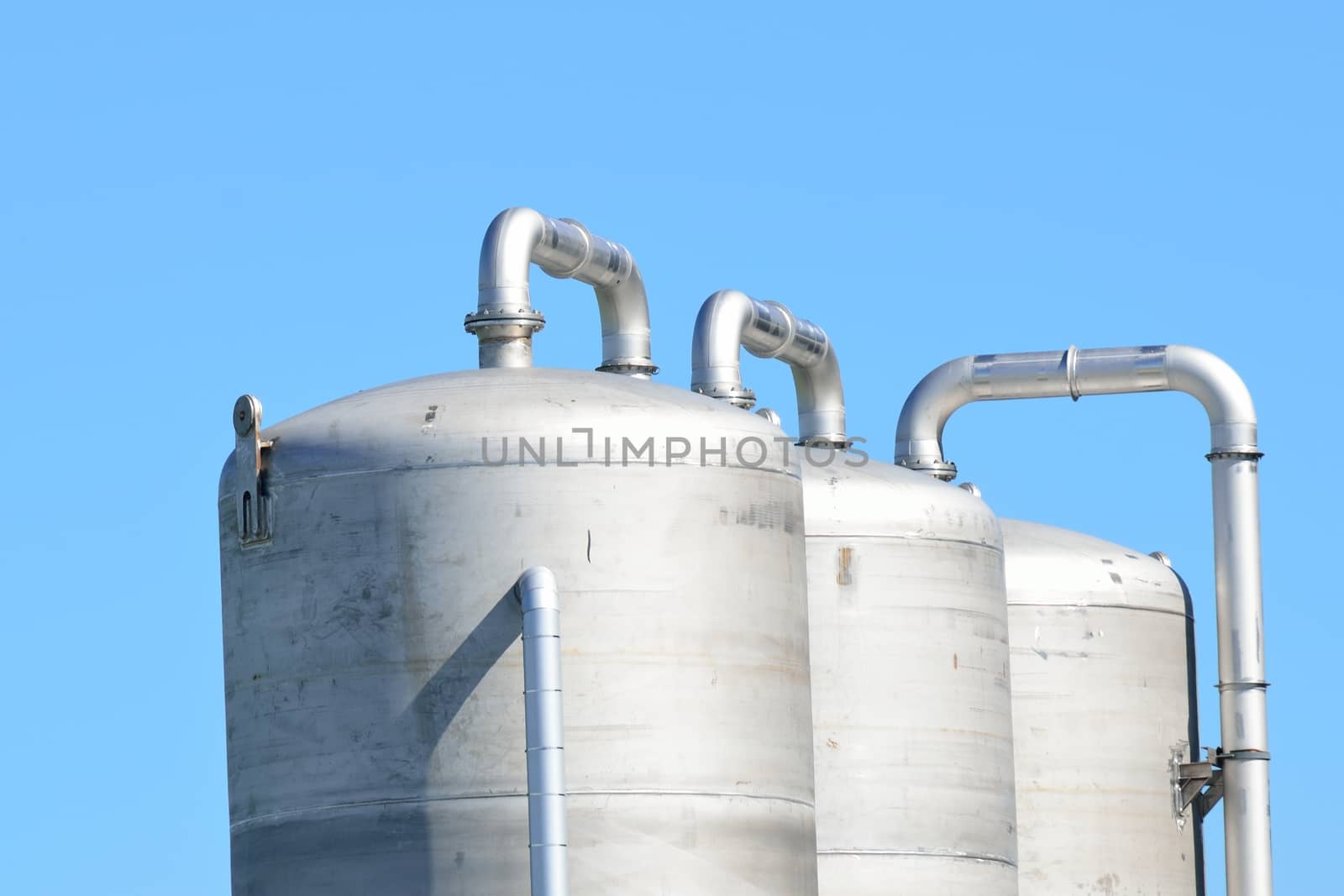 Three steel tanks with sky