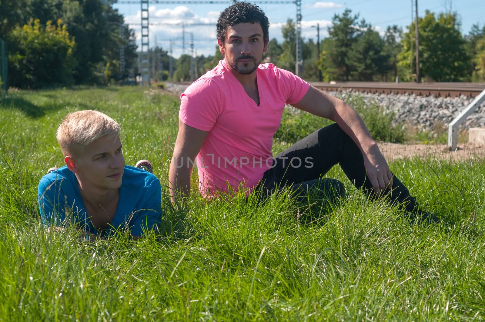 Two handsome young guys sitting on the grass