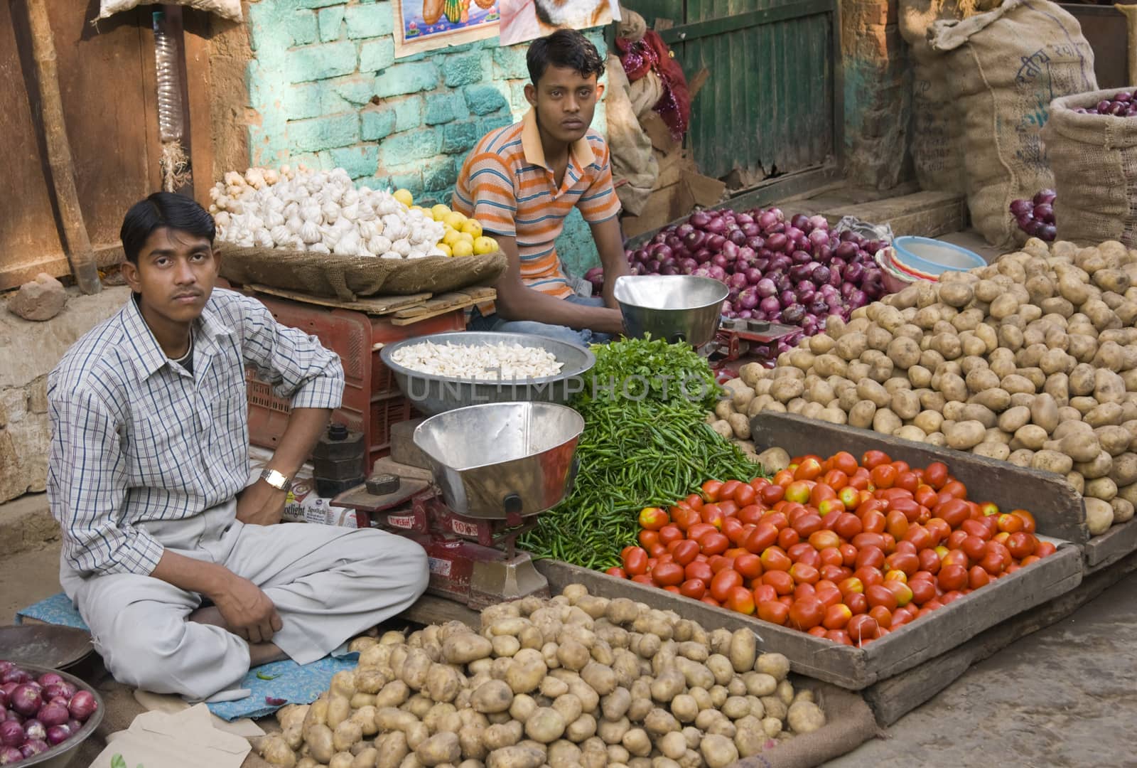 Men selling vegetables from a pavement stall in Delhi, India.