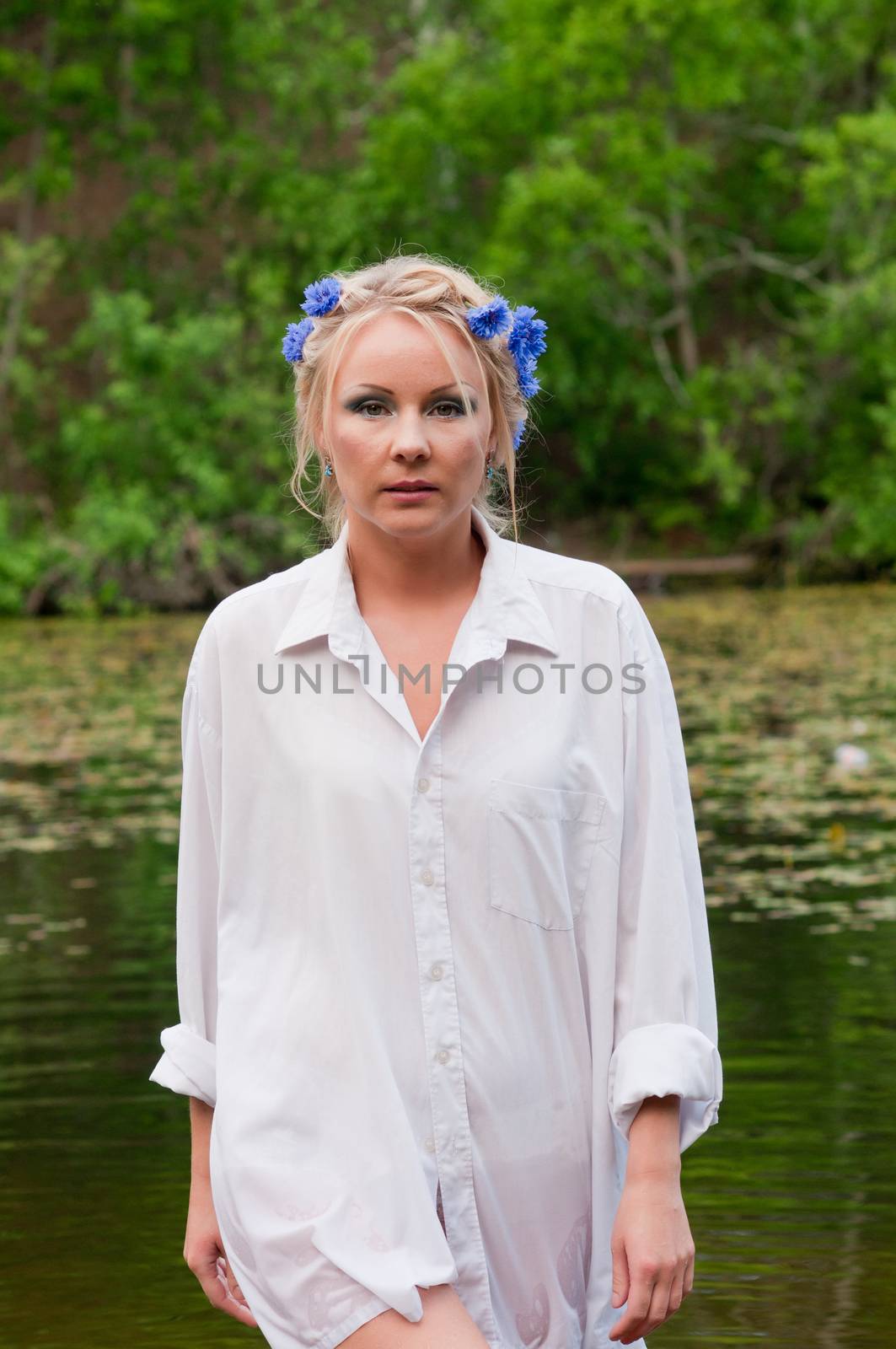Beautiful woman in white shirt coming out from pond