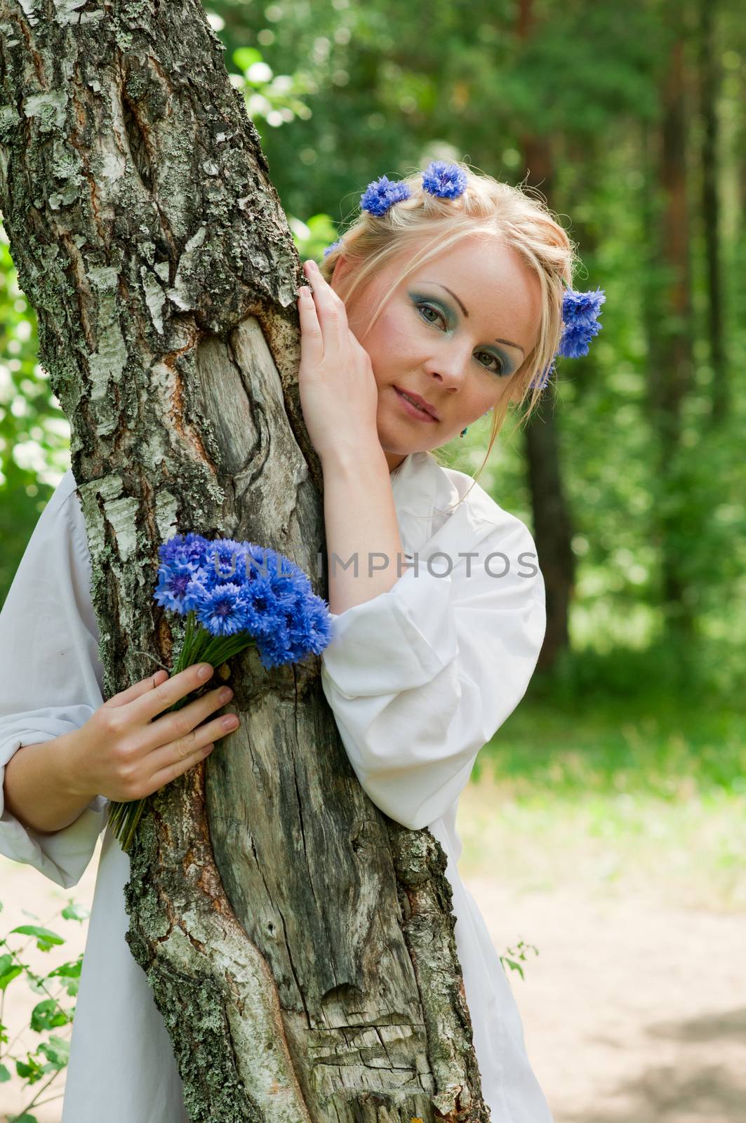 Beautiful young woman hiding behind the tree by anytka