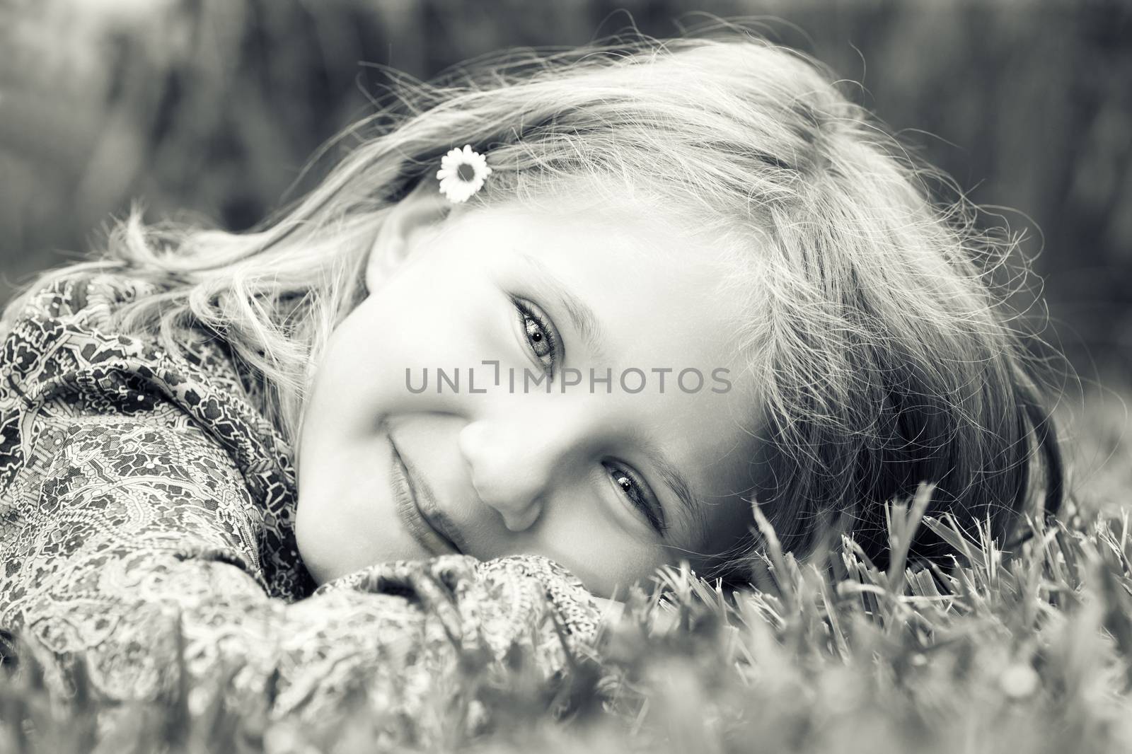 Little adorable girl lying on grass smiling