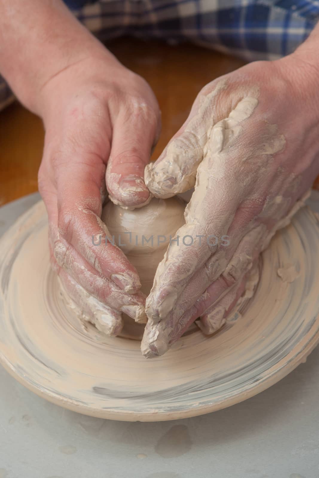 Hands of a potter, creating an earthen jar on the circle