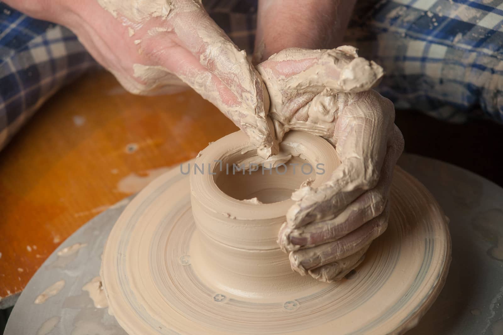 Hands of a potter, creating an earthen jar on the circle