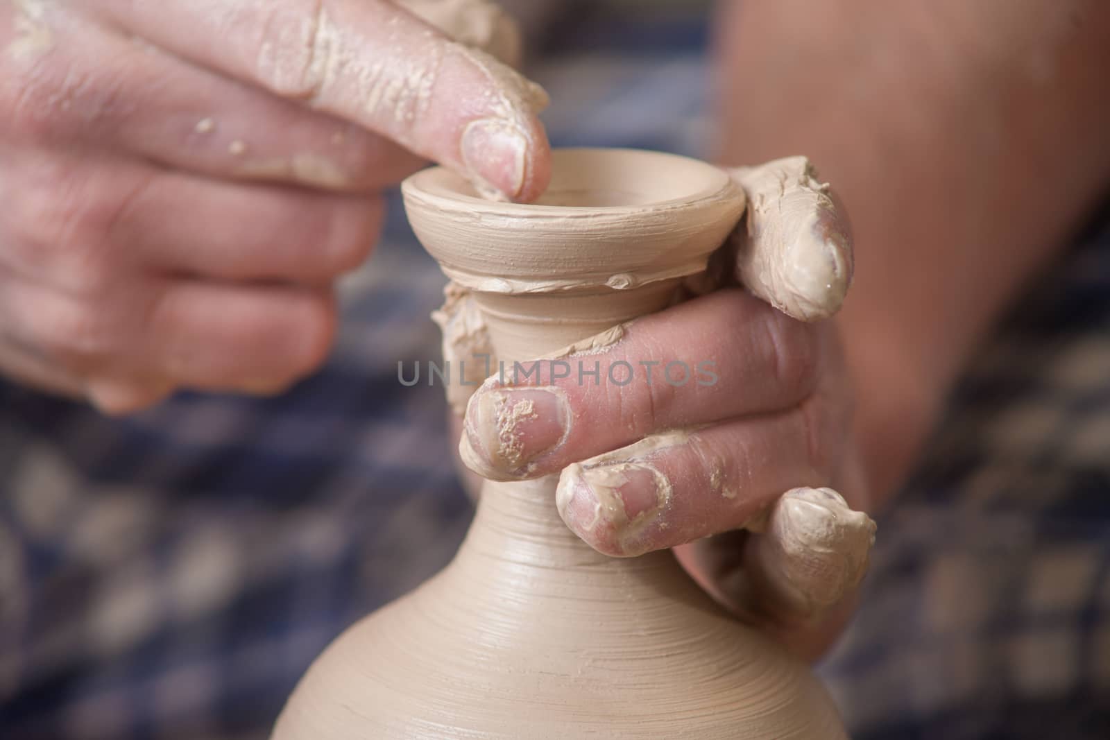 Hands of a potter, creating an earthen jar on the circle