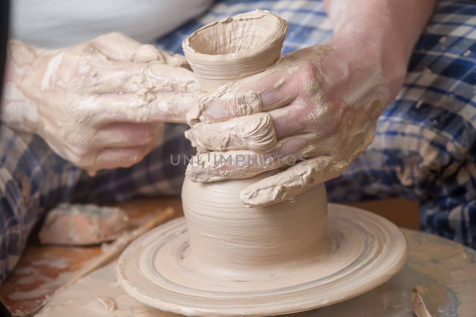 Hands of a potter, creating an earthen jar on the circle