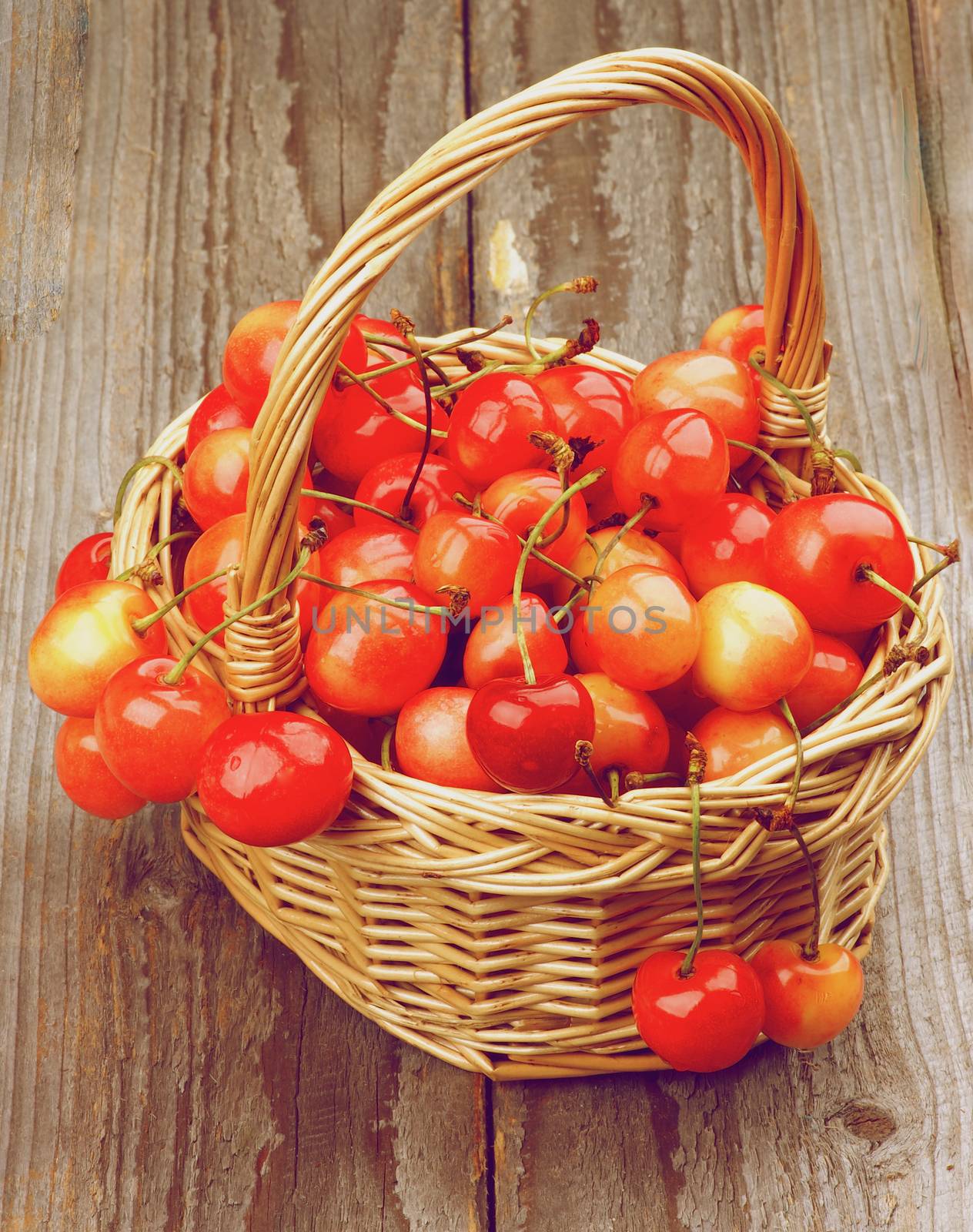 Sweet Maraschino Cherries in Wicker Basket on Wooden background. Retro Styled