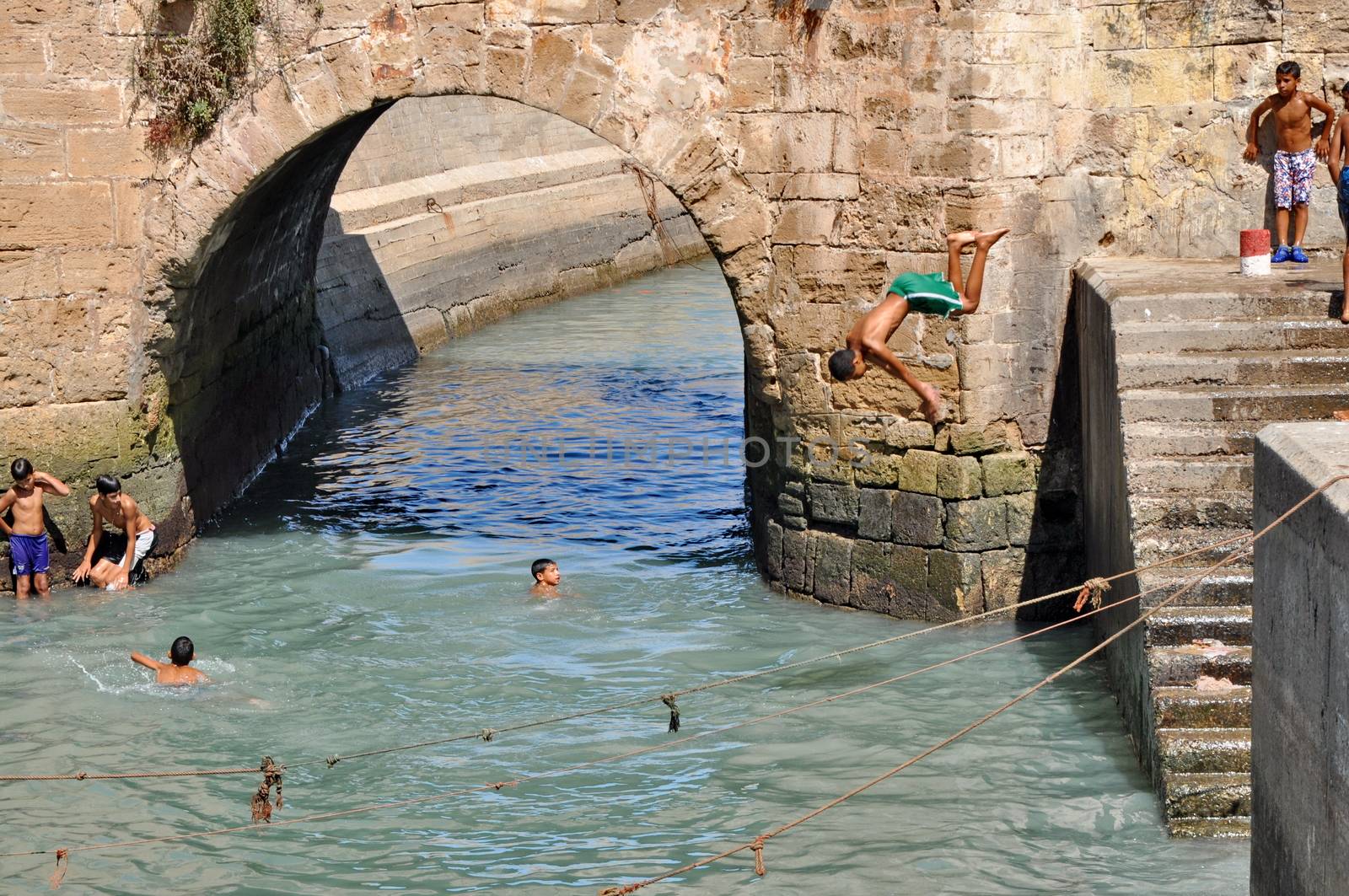 ESSAOUIRA - SEPTEMBER 29: Children take a bath in the canal. Ess by anderm