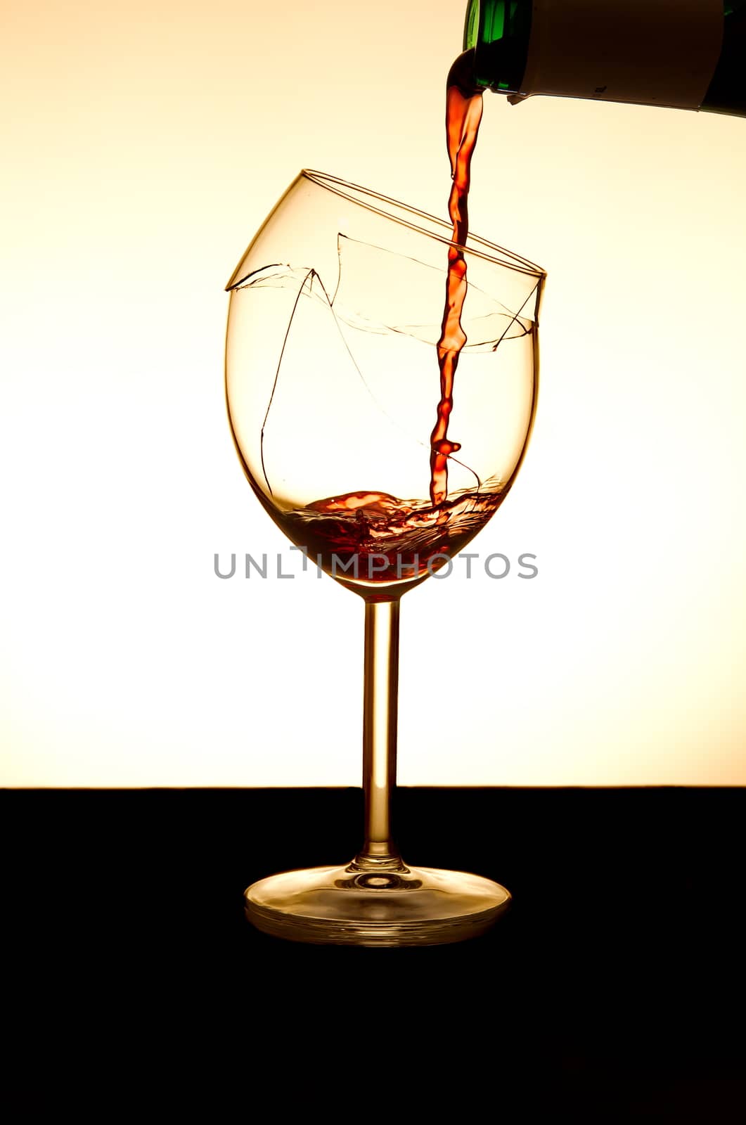Pouring red vine into a broken glass