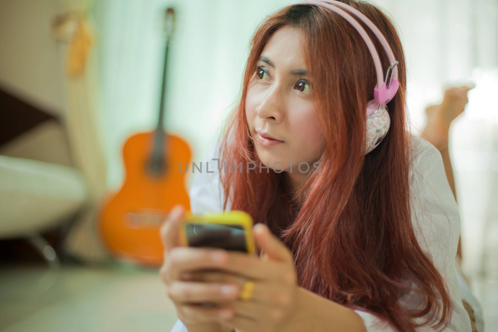 Young asian beautiful woman with smart phone and listening to music at home