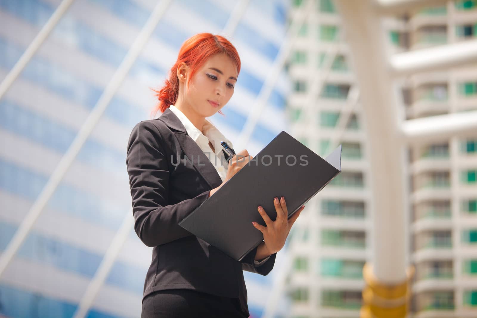 Young business asian woman with document at modern city
