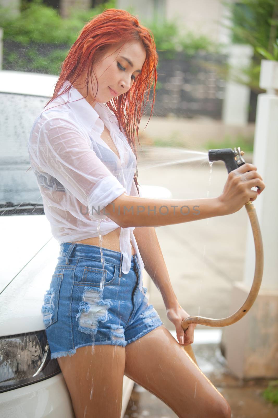 Woman washing a car by witthaya