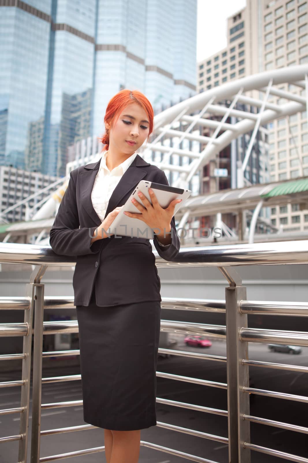 Young business asian woman with tablet at modern city