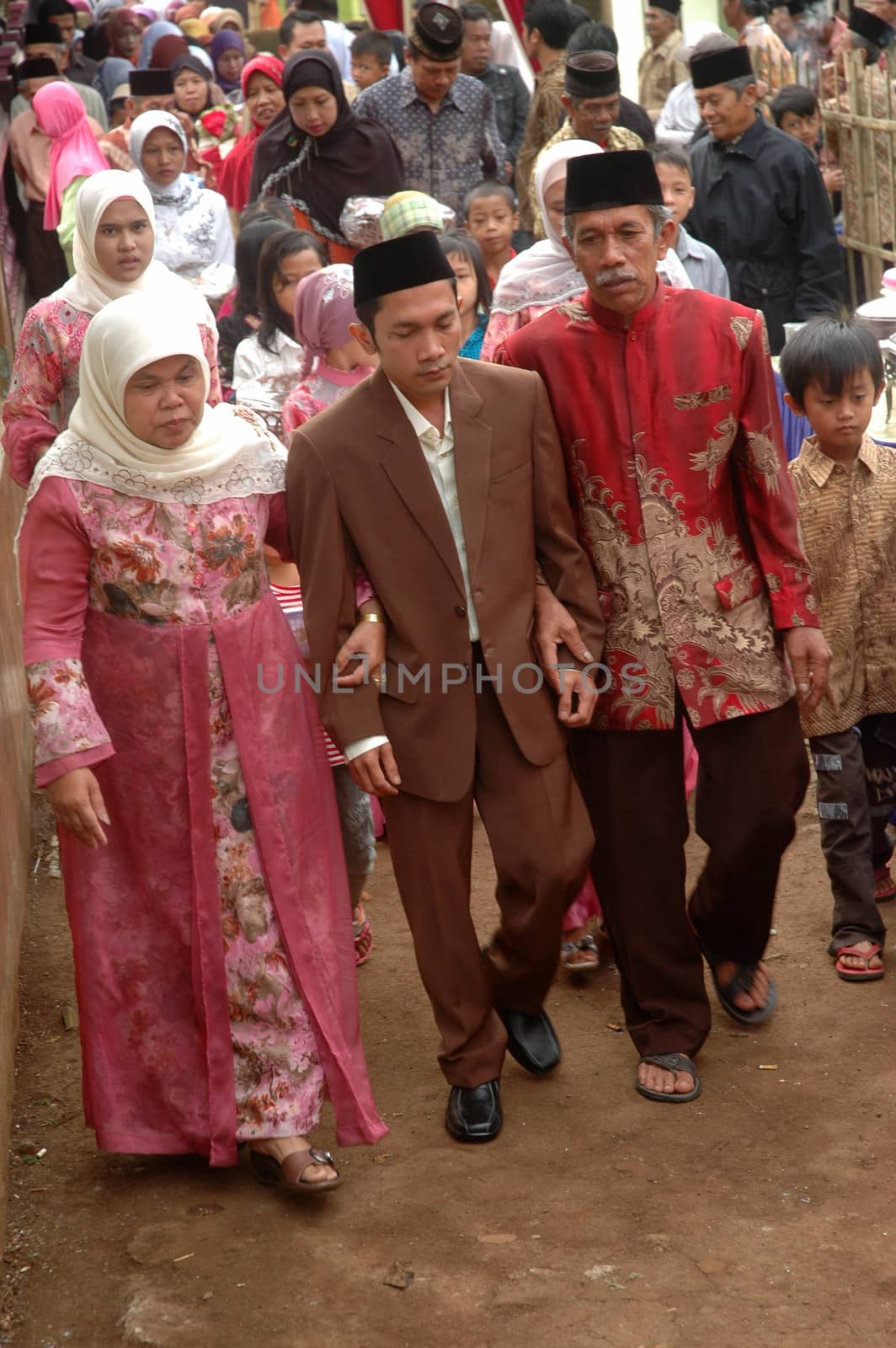 cikijing, west java, indonesia - july 10, 2011: groom and his big family are walking together into the bride house