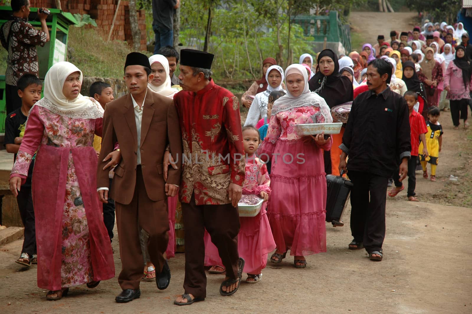 cikijing, west java, indonesia - july 10, 2011: groom and his big family are walking together into the bride house