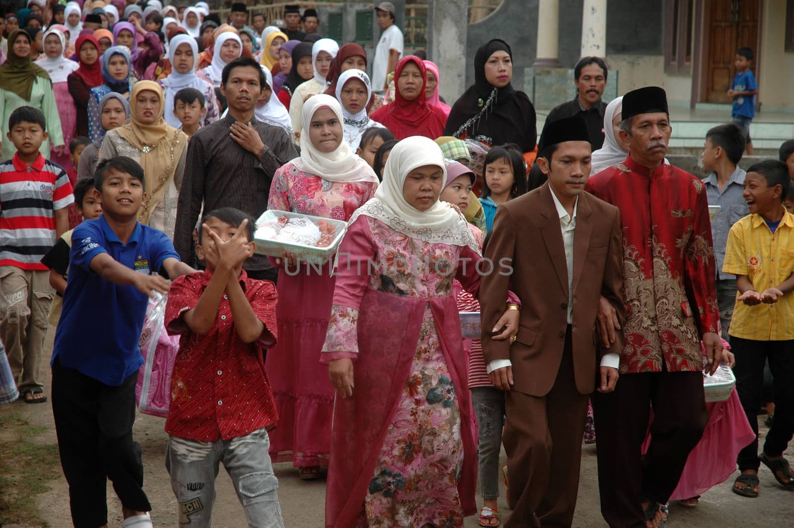 cikijing, west java, indonesia - july 10, 2011: groom and his big family are walking together into the bride house