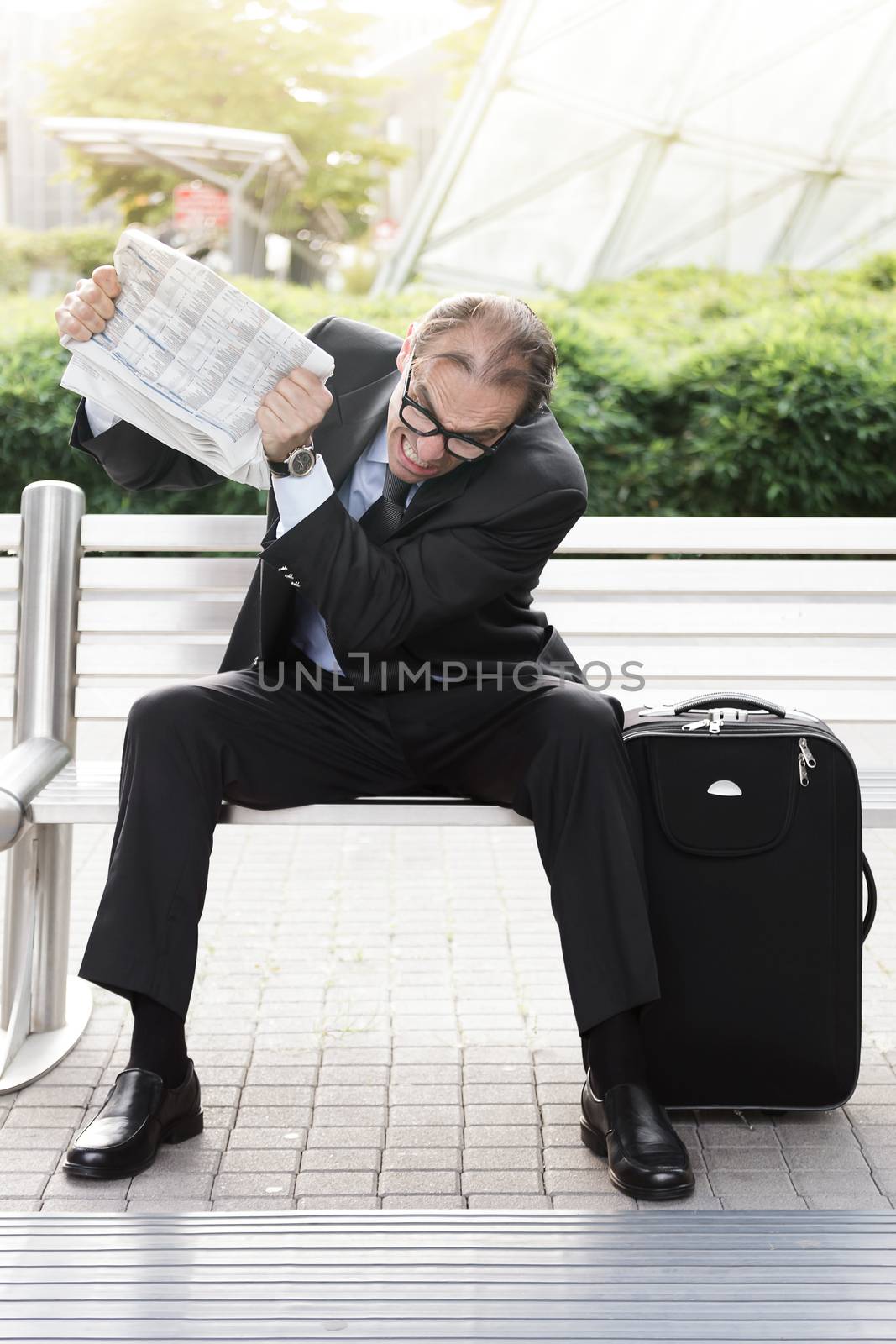 Portrait of Angry businessman with newspaper in his hands 