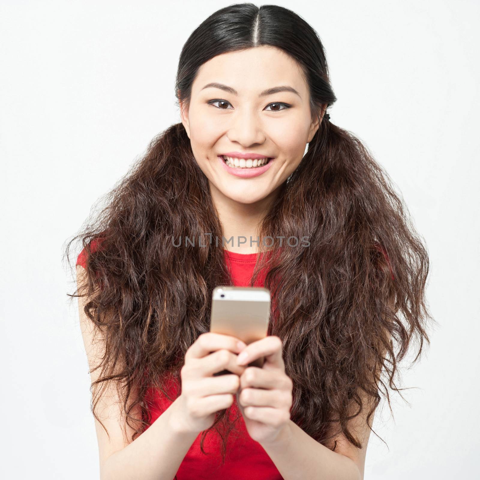 Young smiling girl using cell phone by stockyimages
