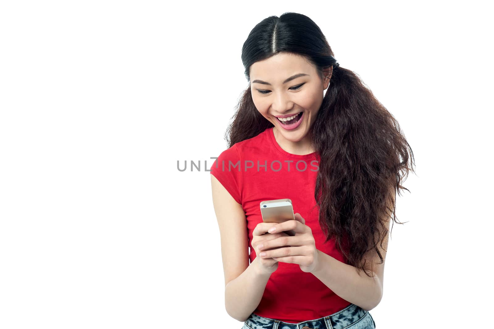 Excited pretty girl sending a text message by stockyimages