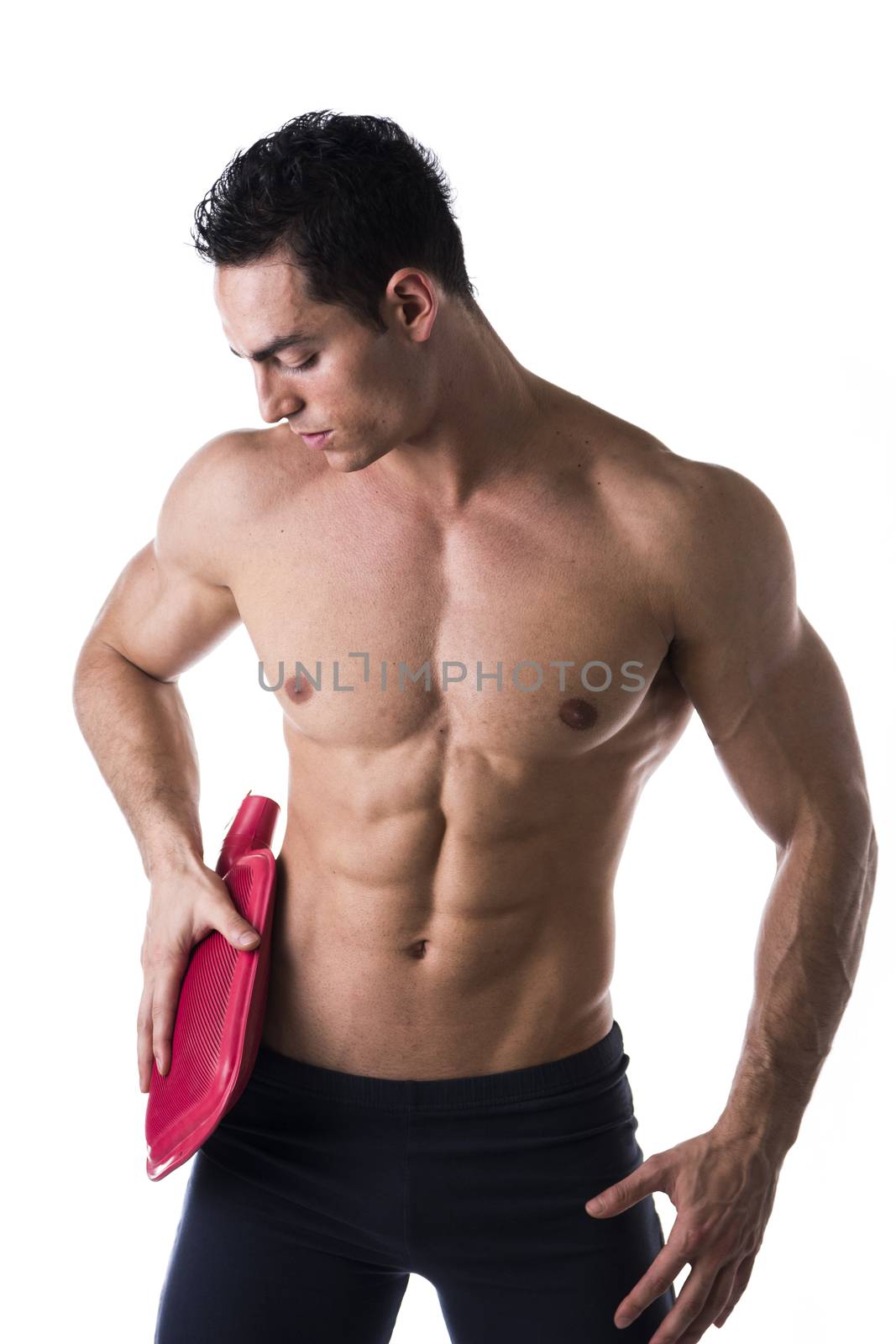 Handsome young man with shoulder pain, holding hot water bottle on waist, isolated