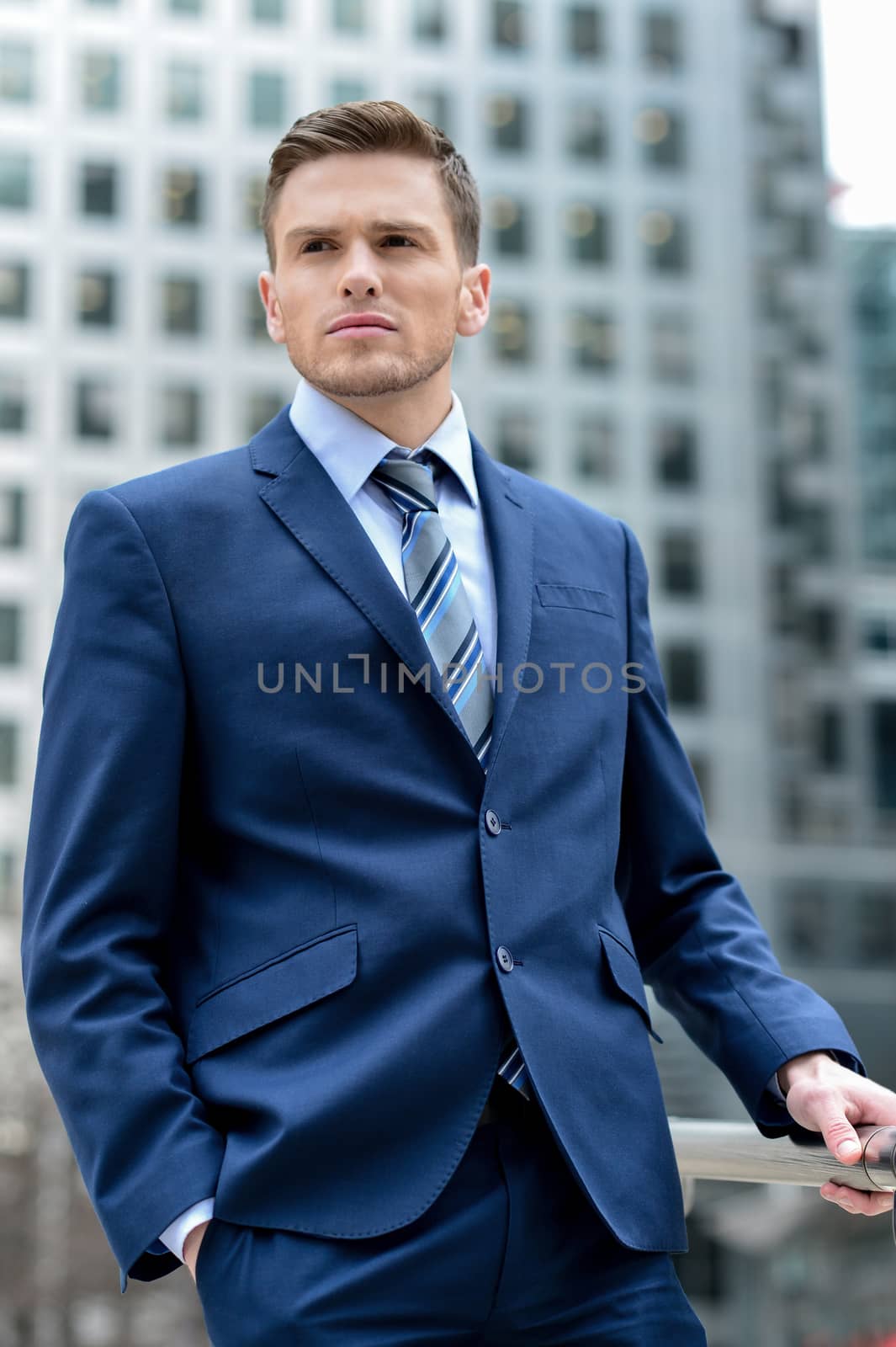 Handsome businessman posing outdoors by stockyimages