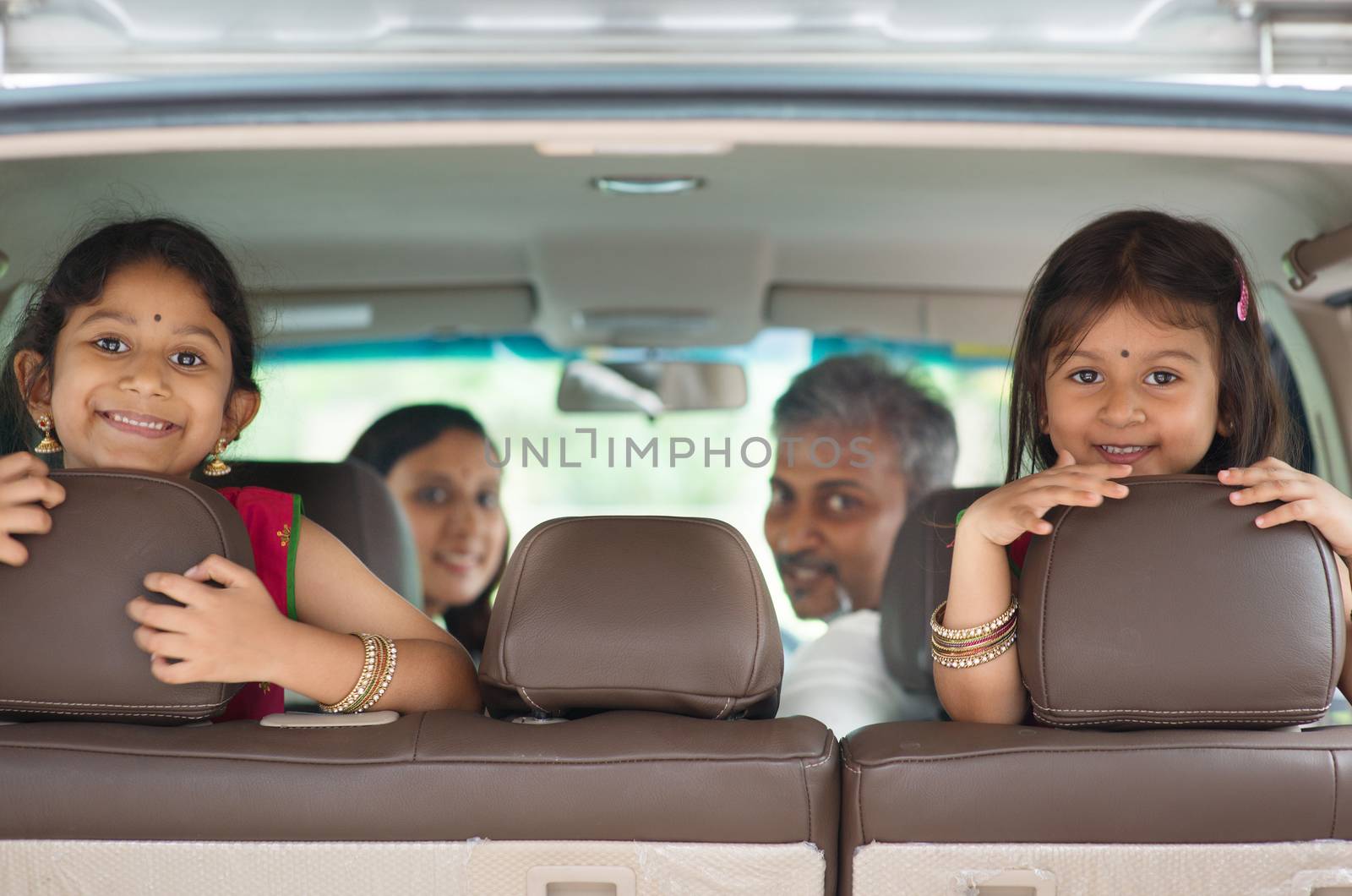 Indian family sitting in car  by szefei