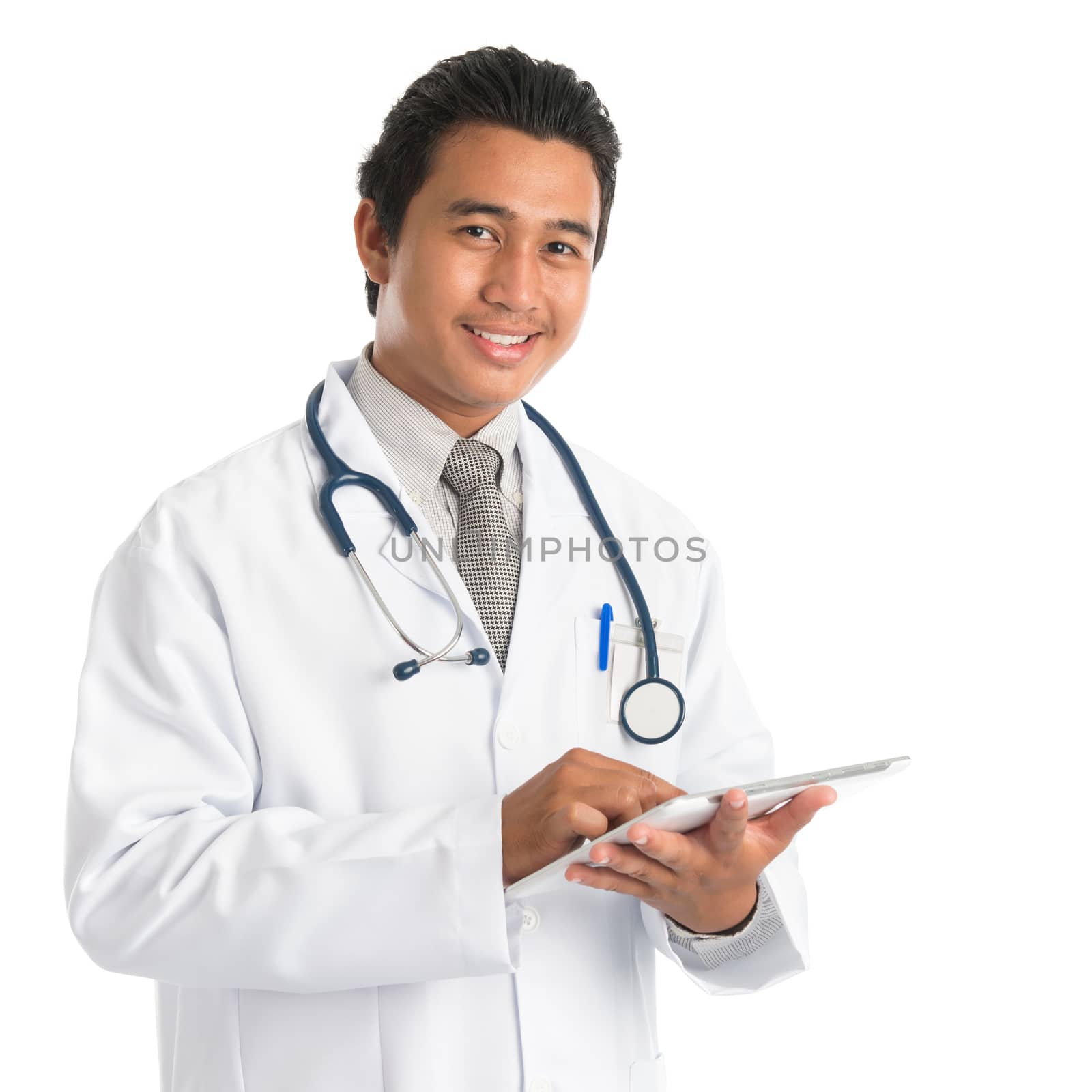 Portrait of southeast Asian male medical doctor using digital tablet computer, standing isolated on white background. Young man model.
