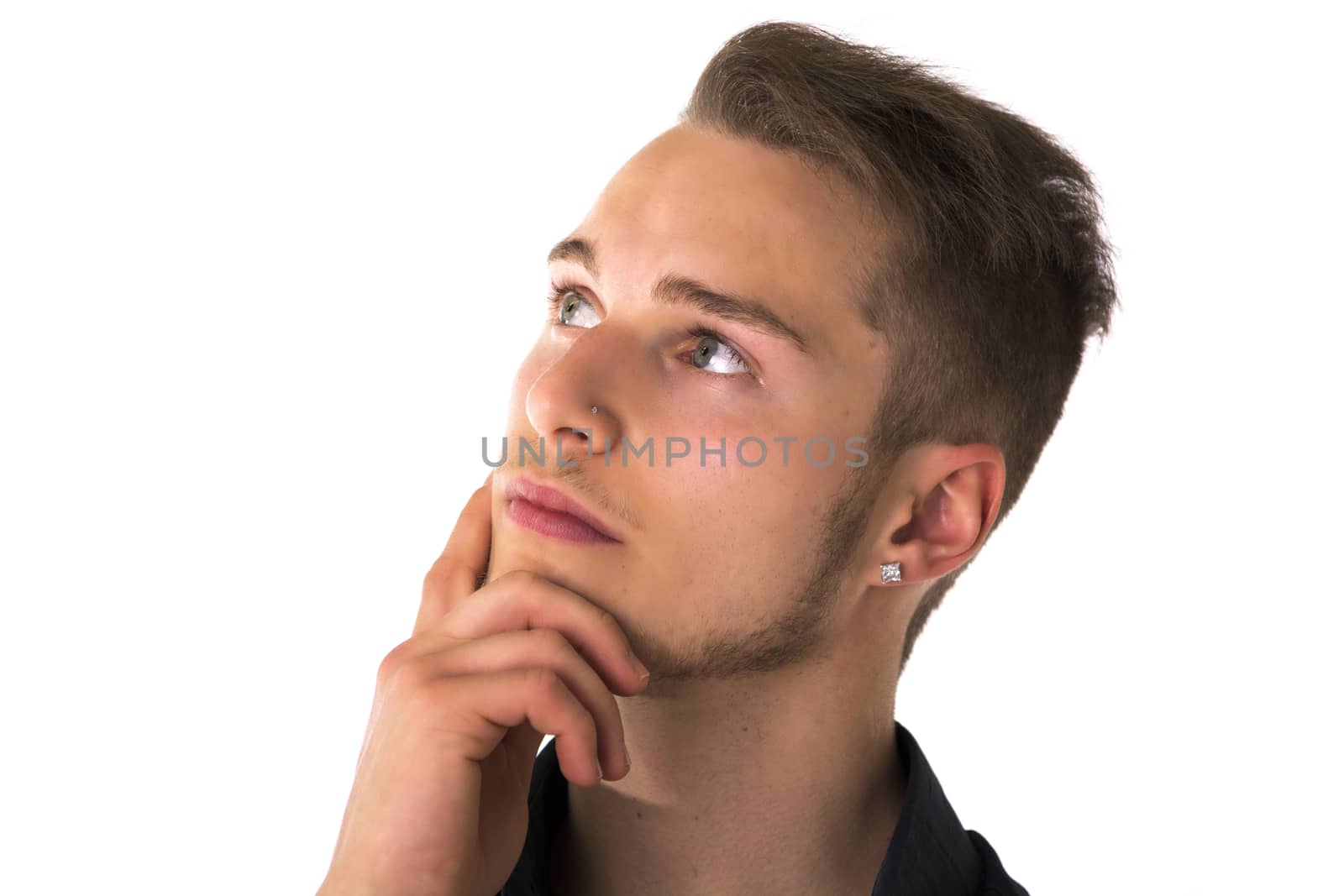Attractive young man thinking, looking up with hand on his chin, isolated on white background