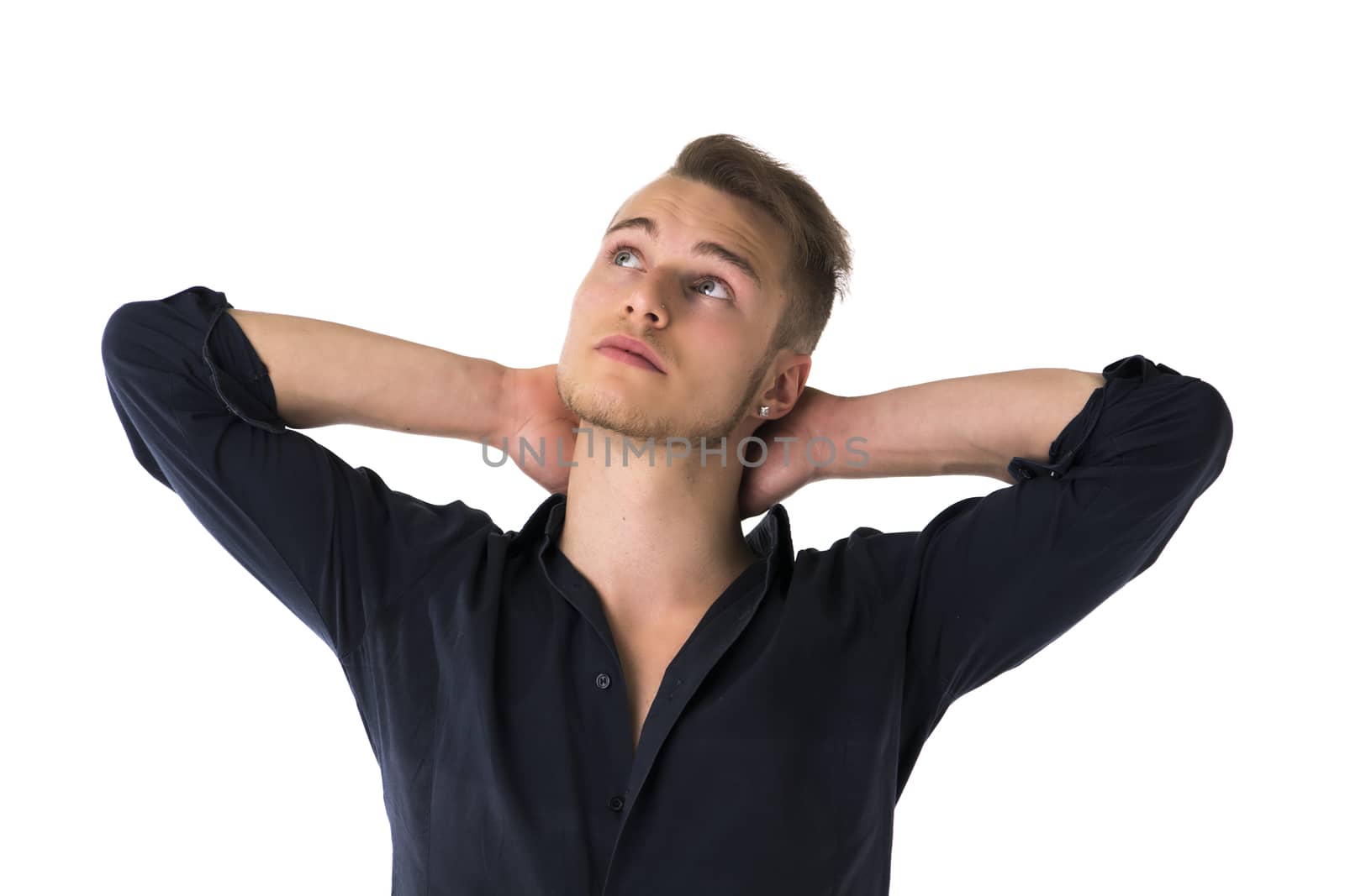 Cool confident blond young man with blue shirt, hands behind head, isolated on white