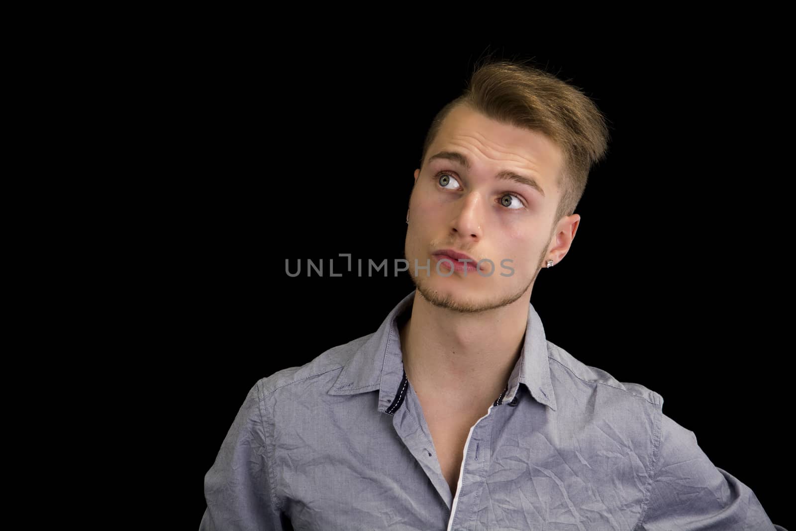 Attractive blond, blue eyed young man with serious expression, looking up, isolated