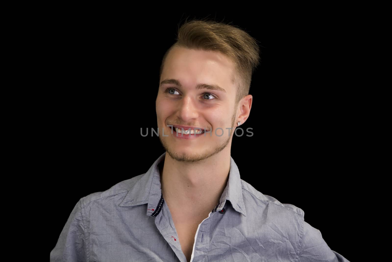 Attractive blond, blue eyed young man smiling and looking away, isolated