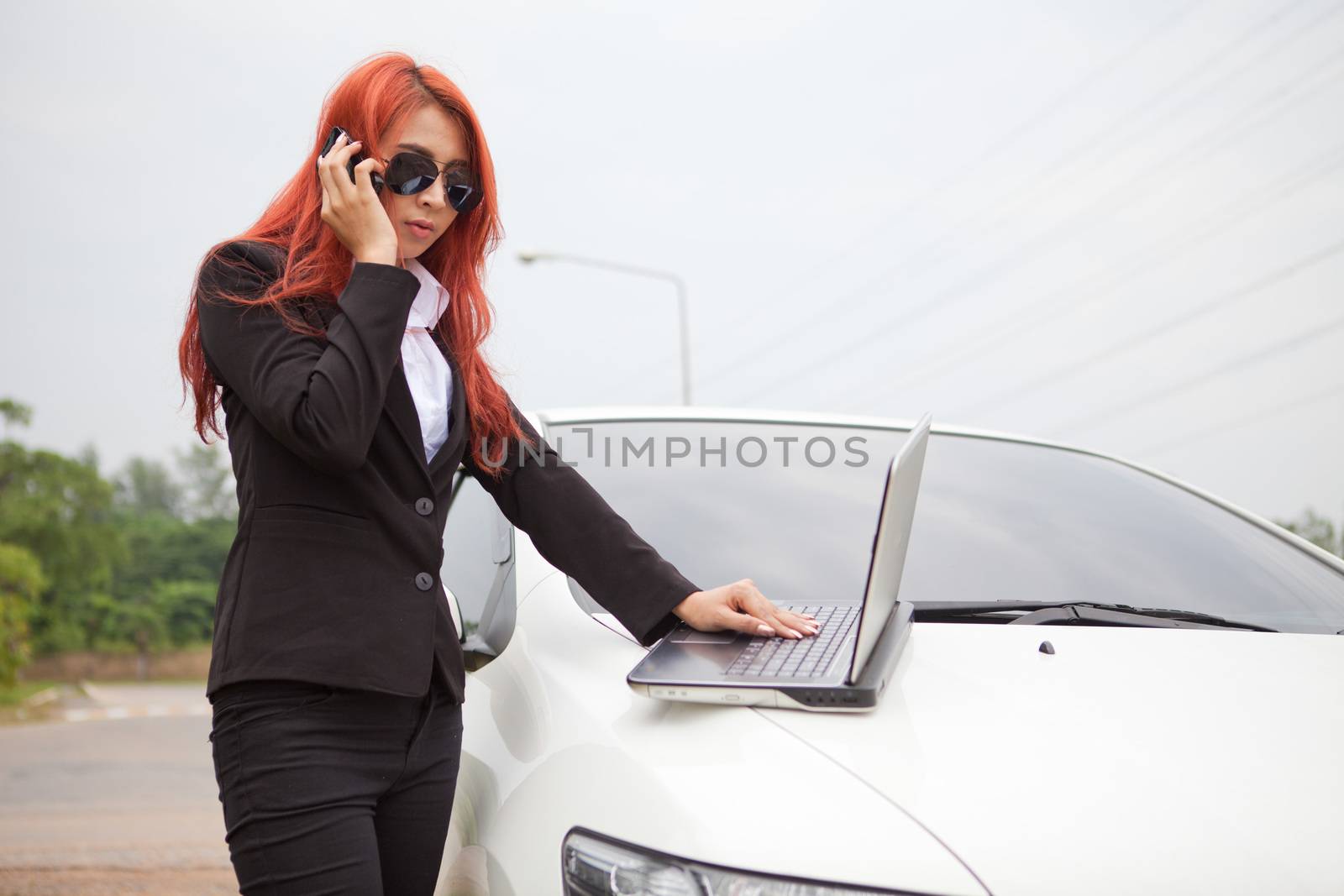 woman using laptop and mobile phone by witthaya