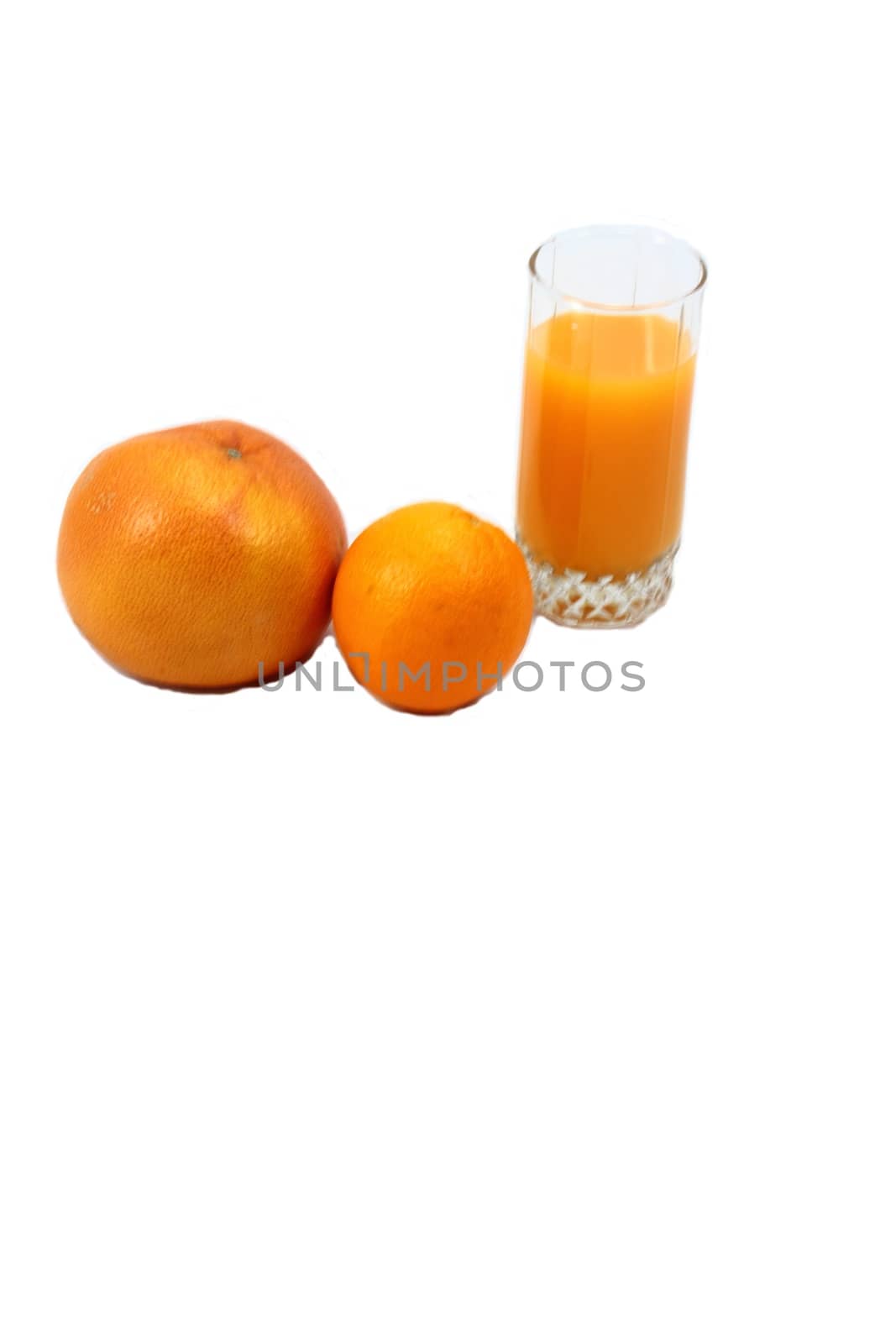 On white background whole grapefruit and orange and glass of orange juice