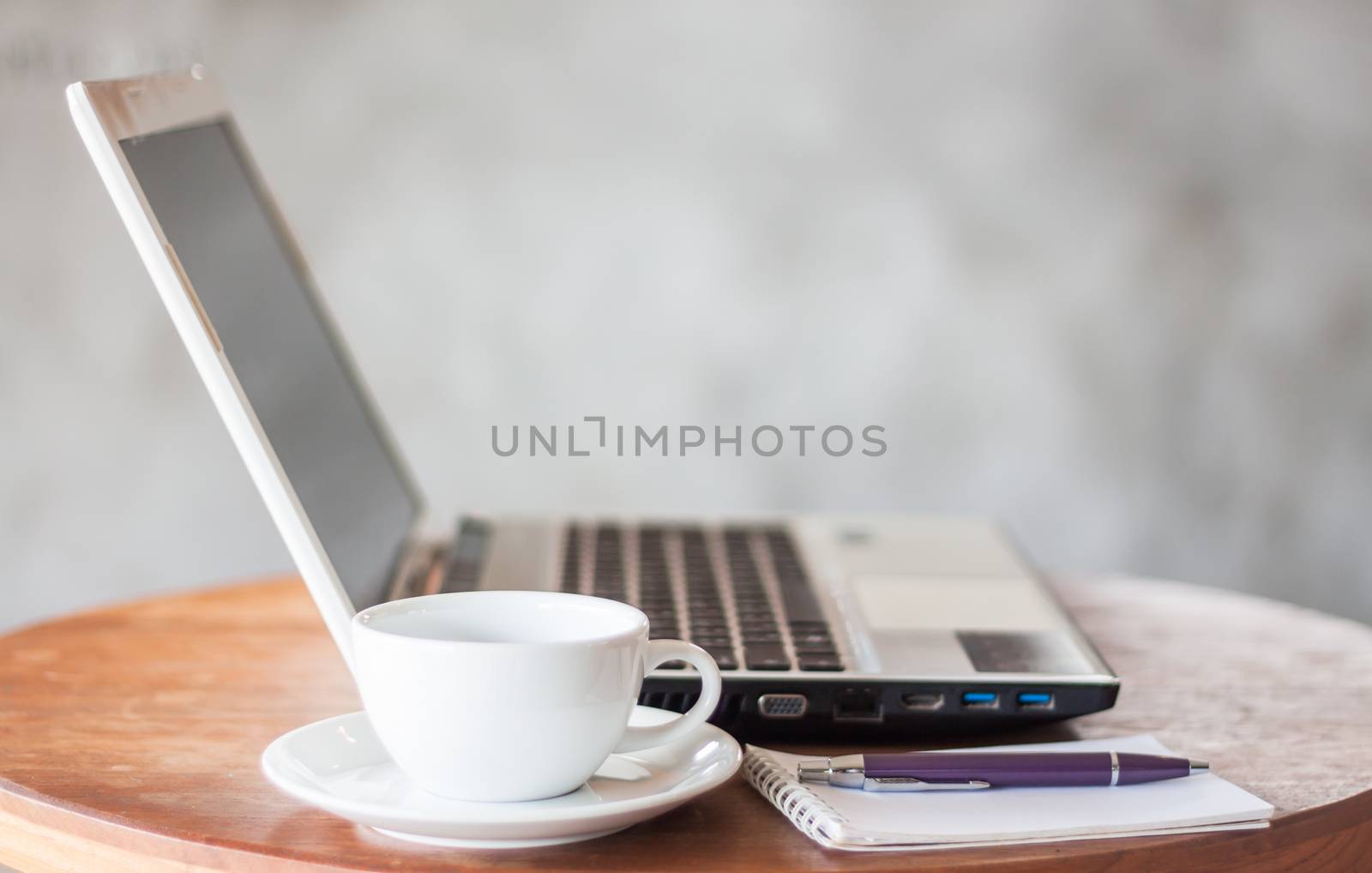 Notepad, laptop and coffee cup on wood table, stock photo