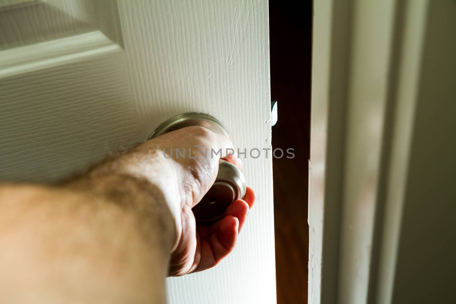 hand on a door knob getting ready to open into the unknown