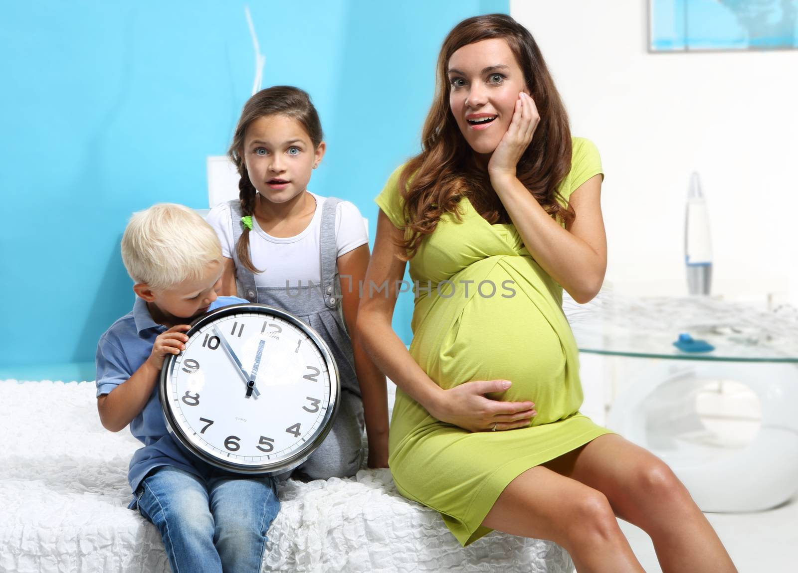 Pregnant mother and children with a clock by robert_przybysz