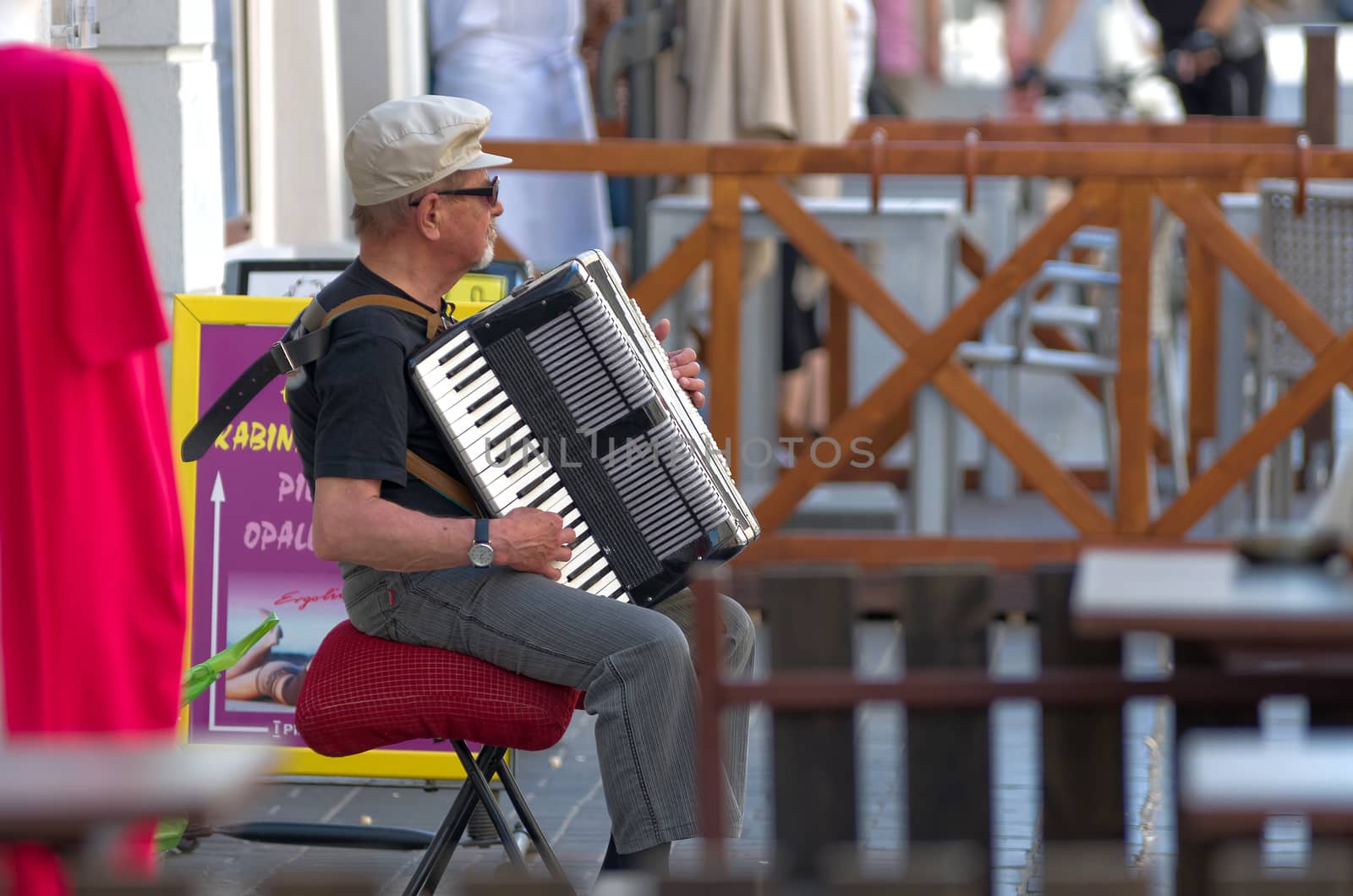 Warsaw, Poland - May 14, 2014: Unknown street musician playing the accordion in the street.