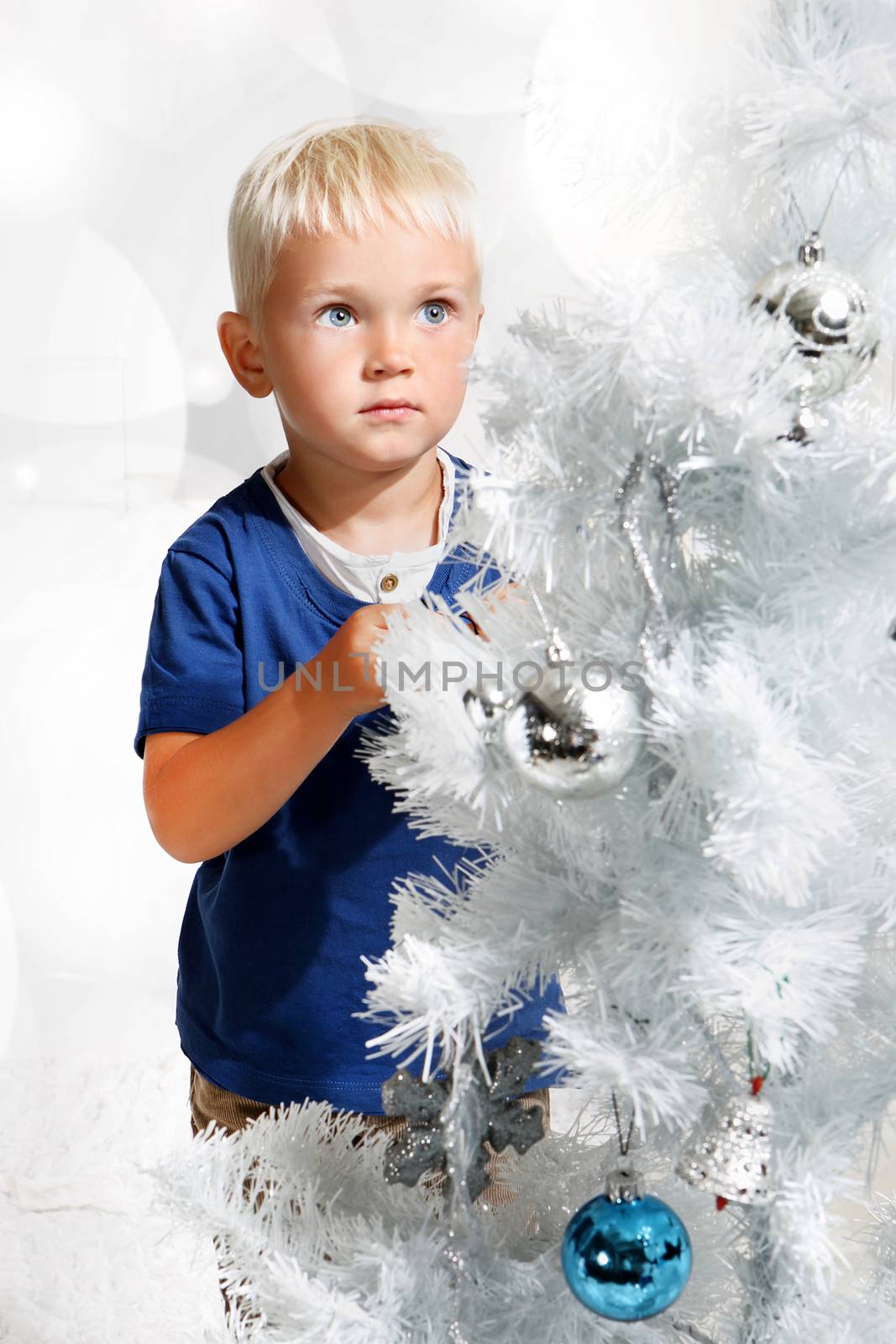 Boy dresses up Christmas tree