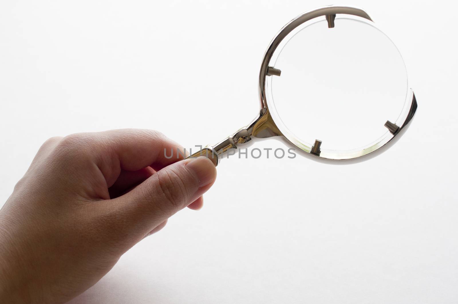 Woman's hand holding magnifying glass