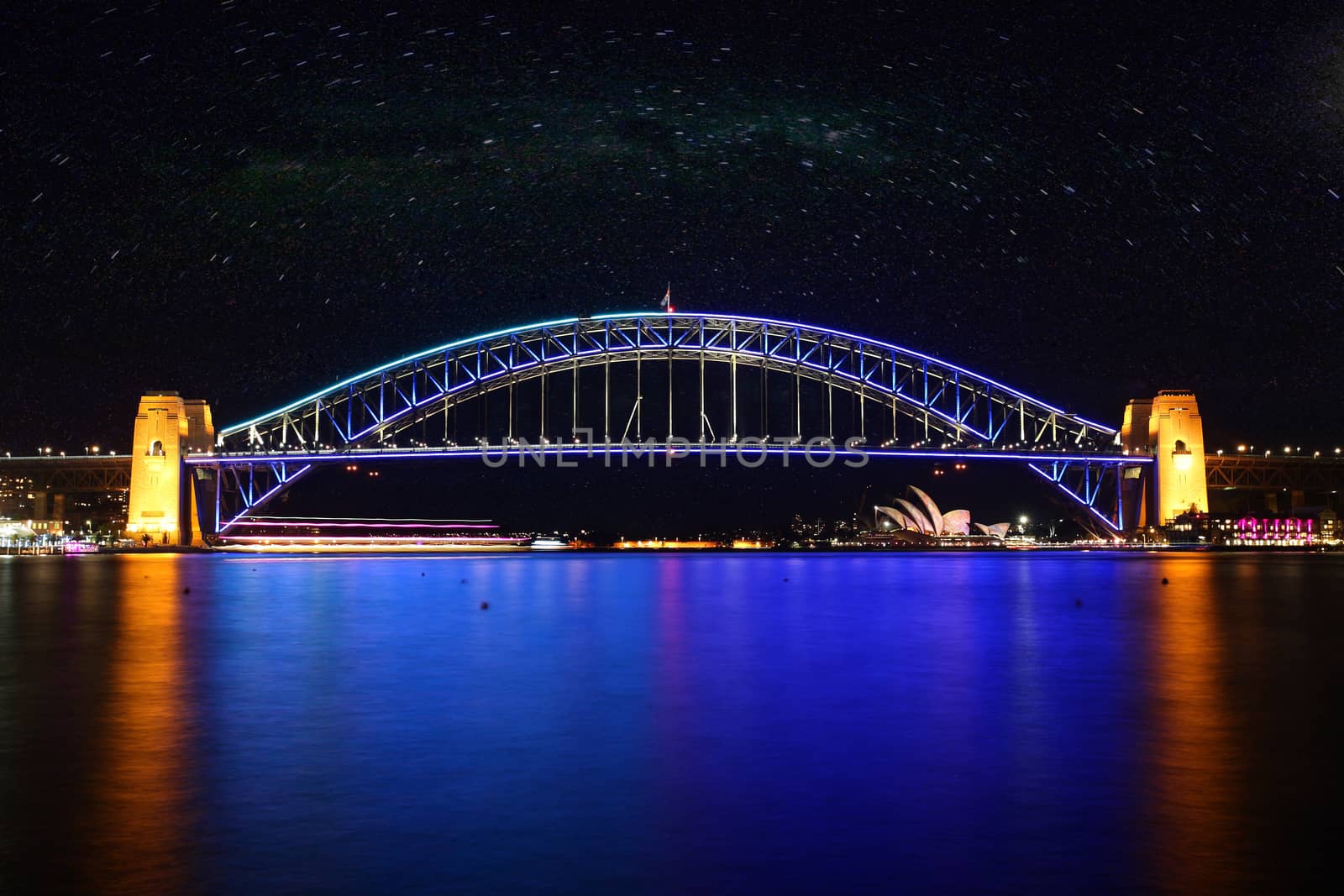 SYDNEY, AUSTRALIA - JUNE 2, 2014; The Sydney Harbour Bridge glows in a colours of beautiful blue and aqua during Vivid Annual Festival event under a clear night sky.  Long Exposure