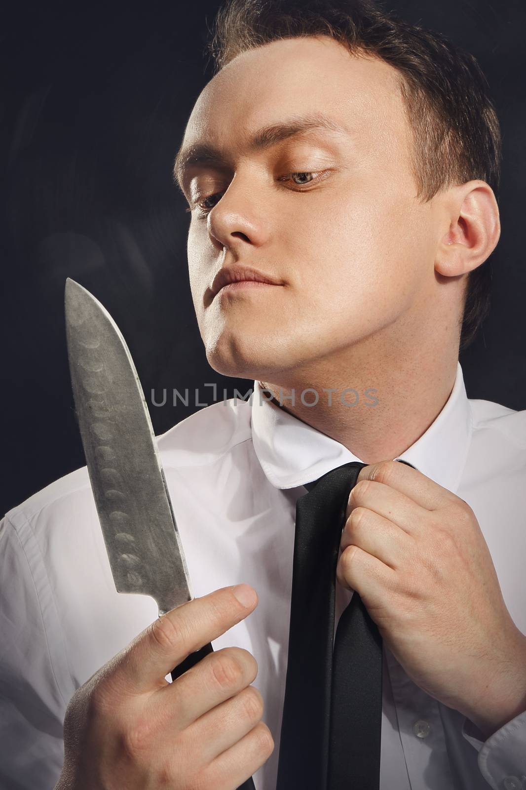 Portrait of a young man browsing in knife blade. by robert_przybysz