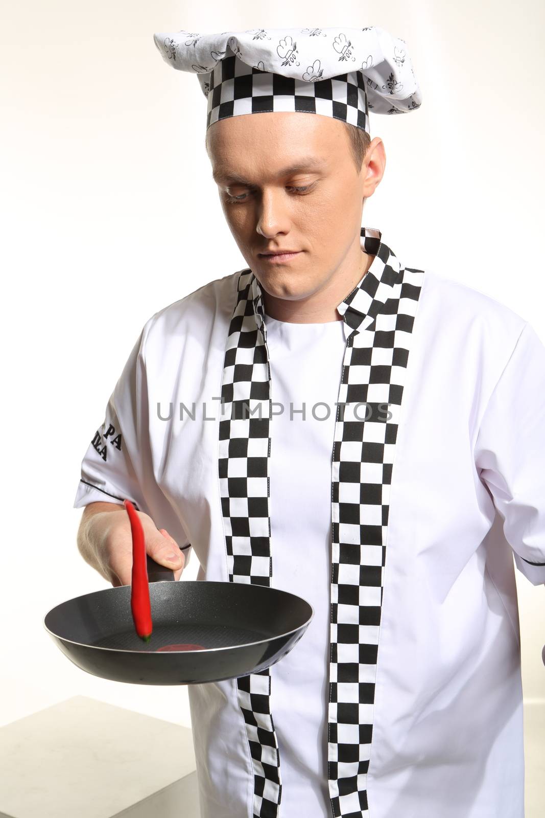 Portrait of young chef in uniform acrid chilli.