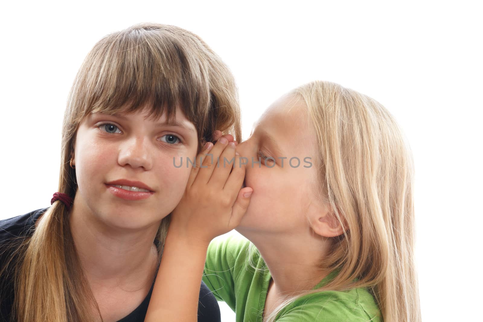 a blonde girl whispering into a brunettes ear