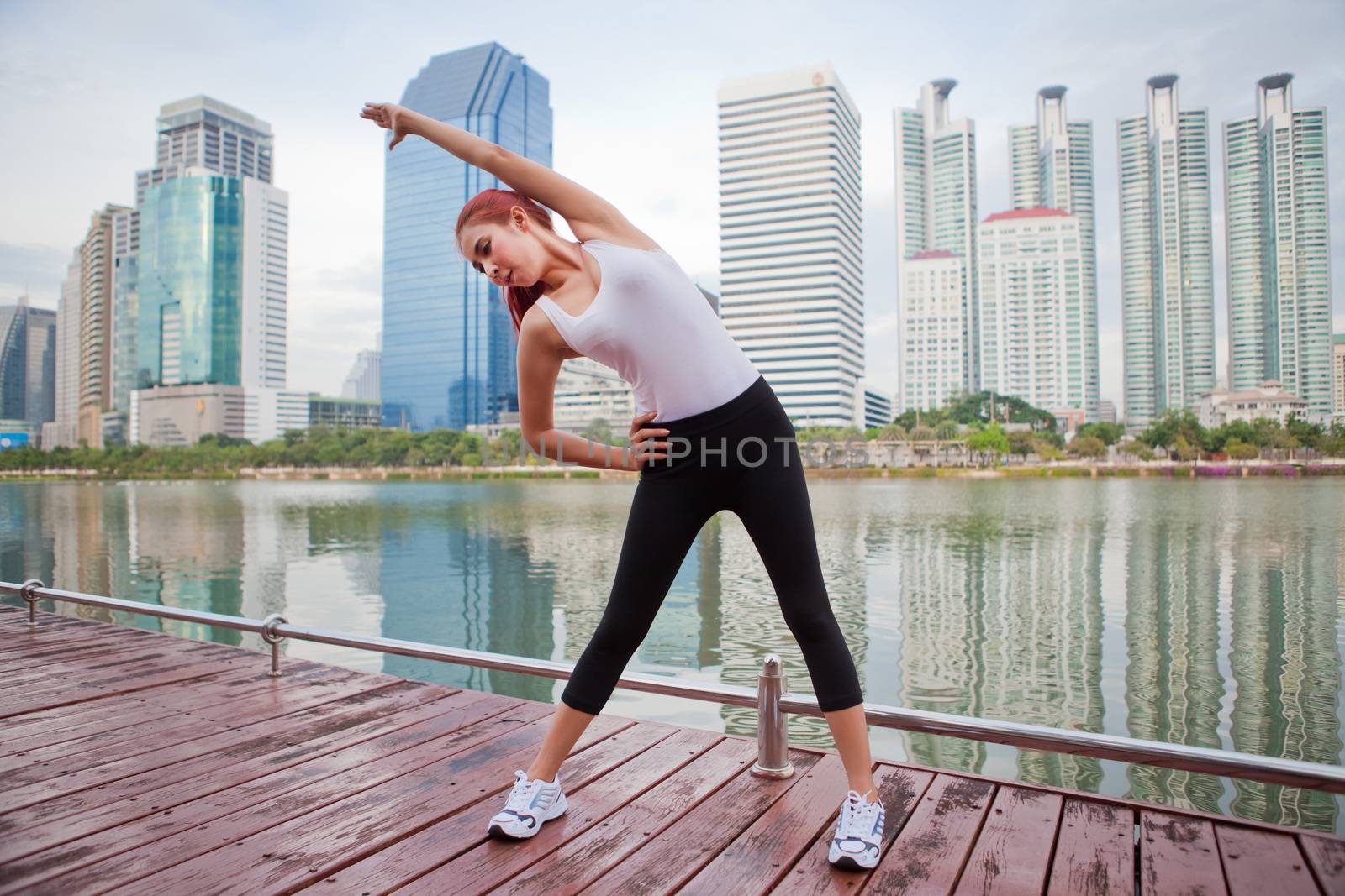 Beautiful young asian woman doing stretching exercise in the city