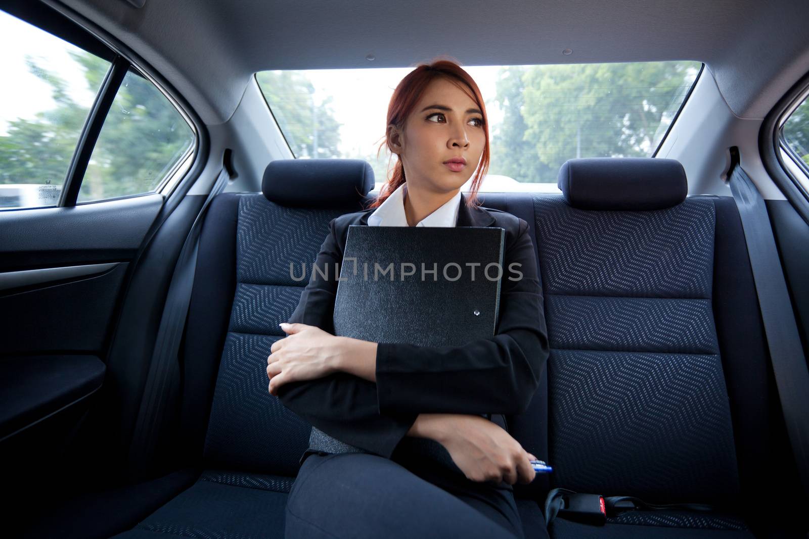 Beautiful young business asian with document in a car