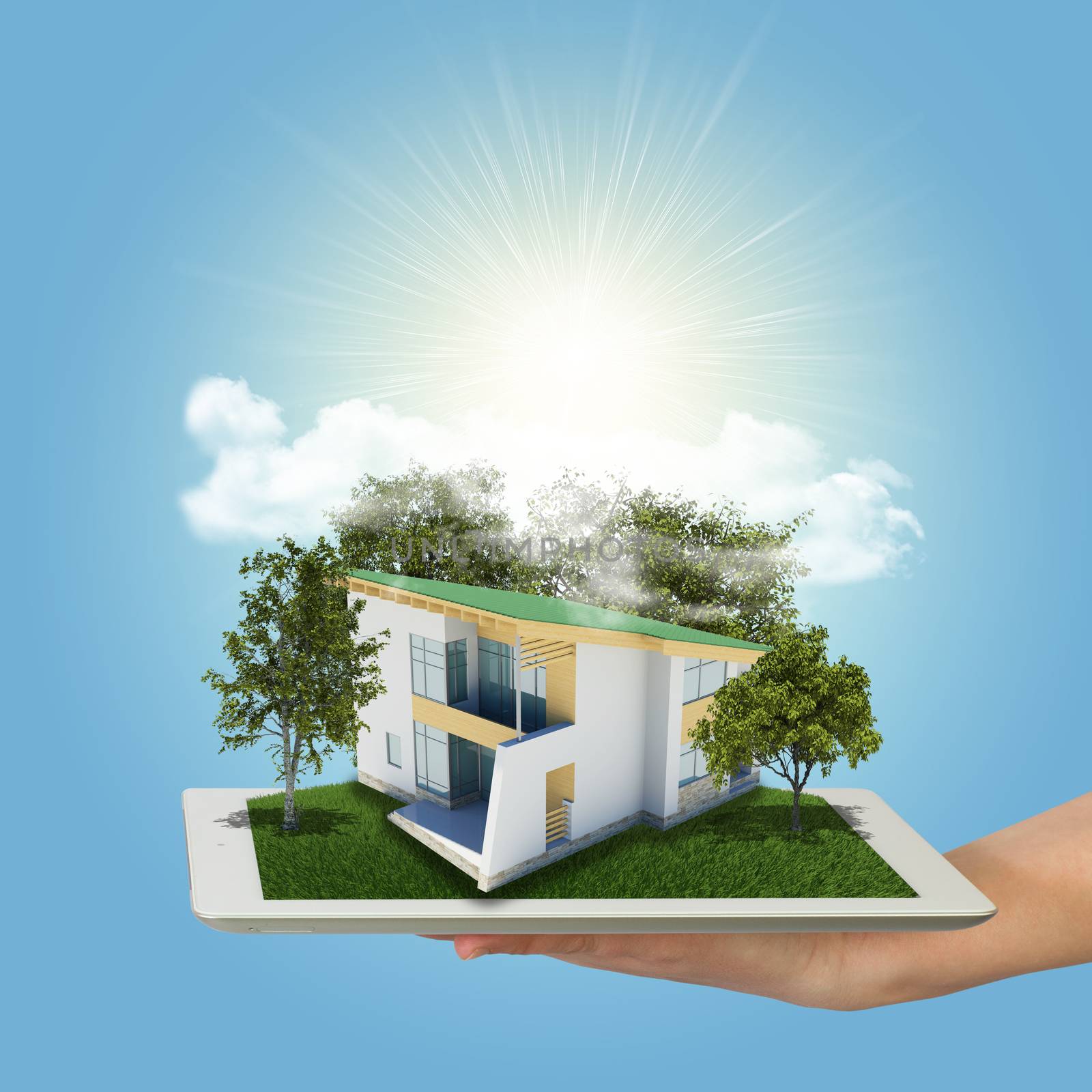 Hands holding tablet pc and small house with land by cherezoff