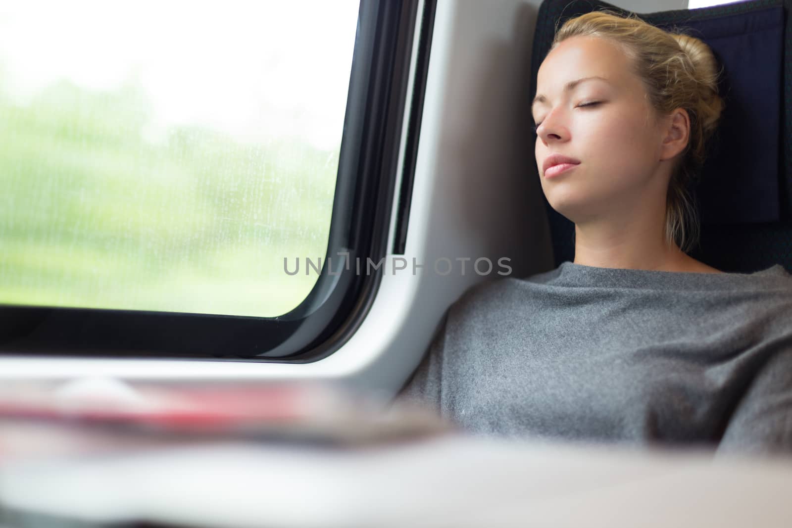 Lady traveling napping on a train. by kasto