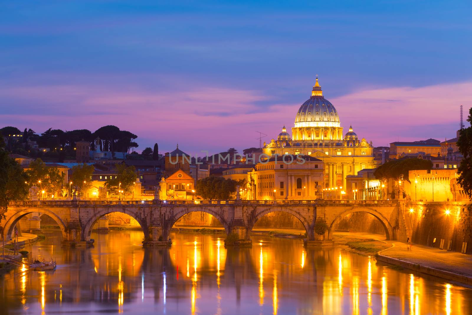 Night view of old roman Bridge of Hadrian and St. Peter's cathedral in Vatican City, Rome, Italy.