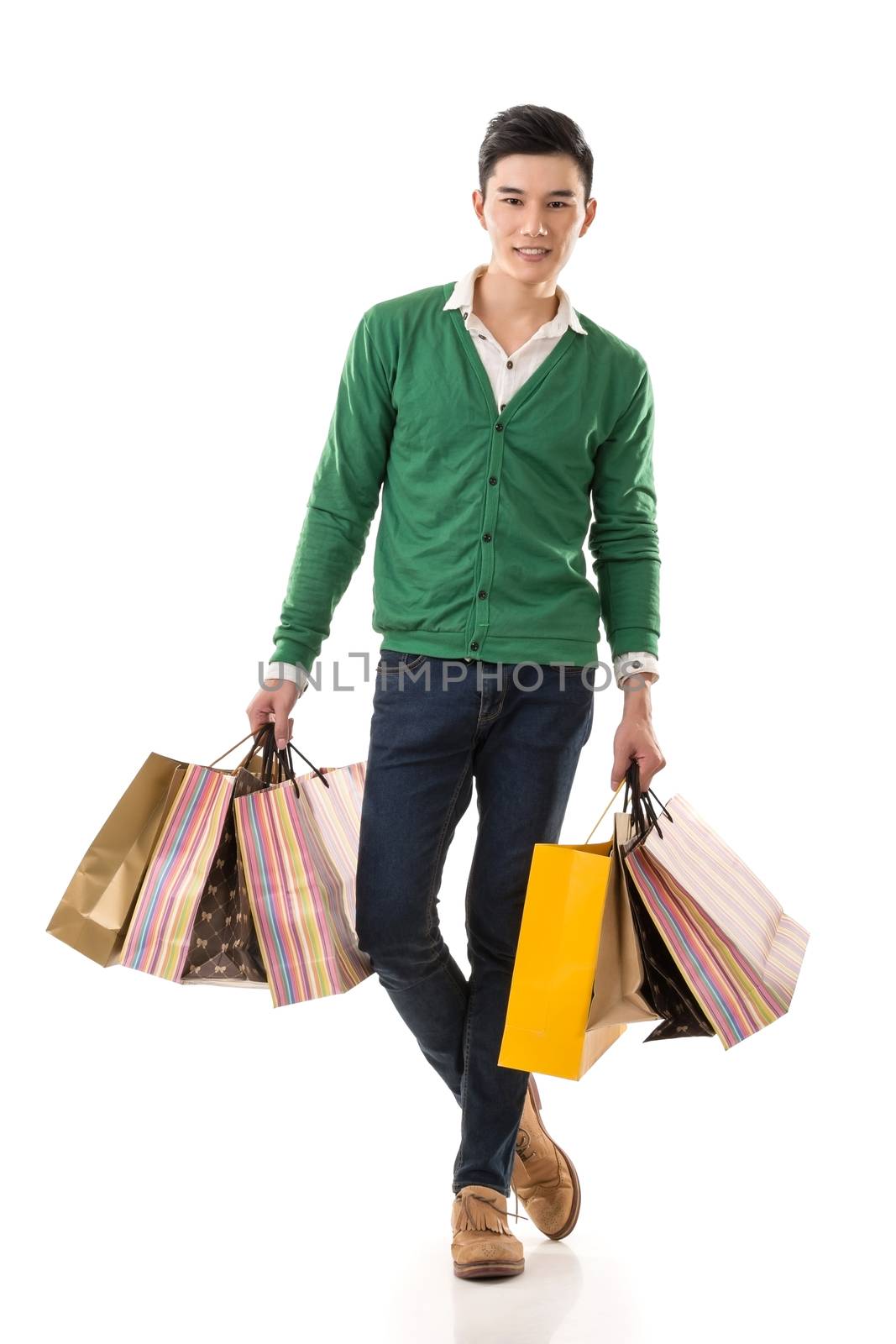 Young Asian man shopping and holding bags, full length portrait isolated on white background.