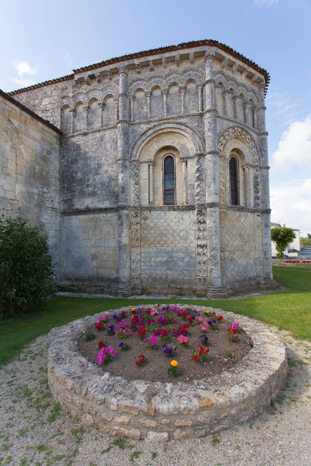 Abse and flowers of the romanesque Rioux church,Charente, France